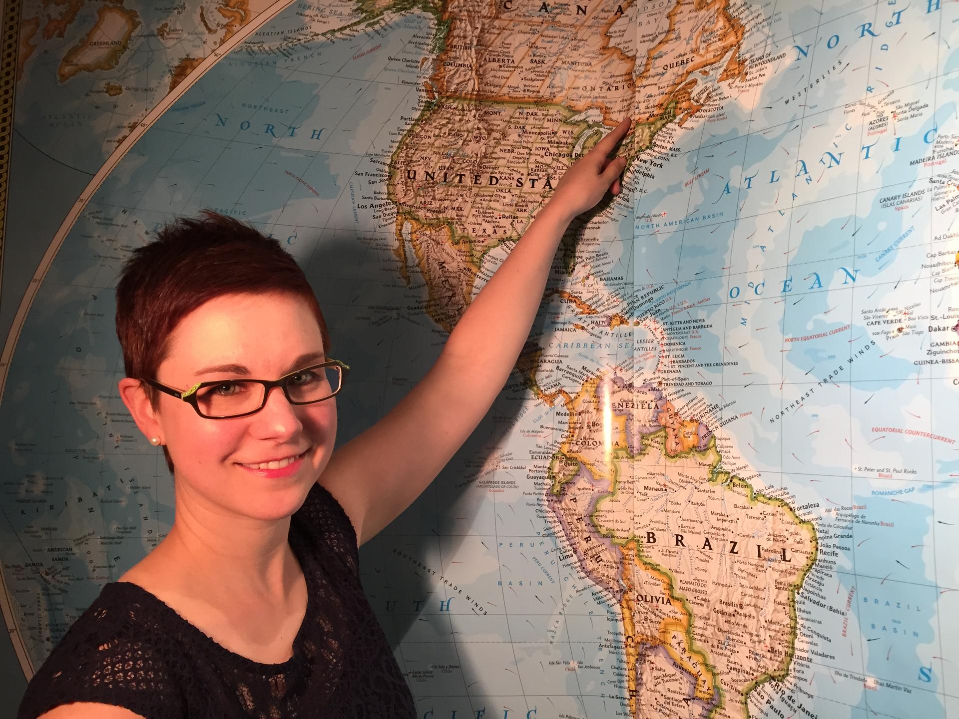 April Verch pointing to Ottawa Valley on a world map in the Nan and Bill Harris studios at WGBH