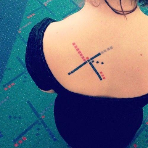 A woman shows her tattoo based on the design of the carpet at the Portland airport.
