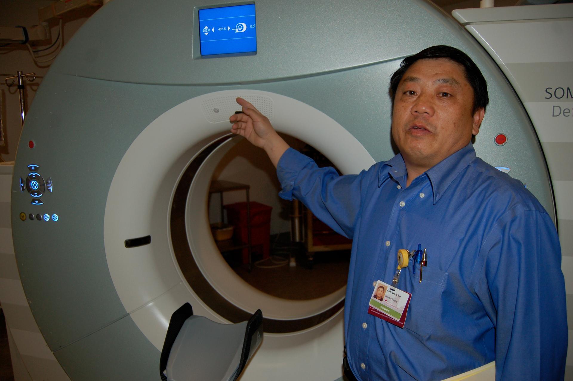 Changvang Her demonstrates how a CAT Scan machine at Mercy Medical Center plays an automated recording of his voice giving directions in Hmong — for when he's not around to translate.