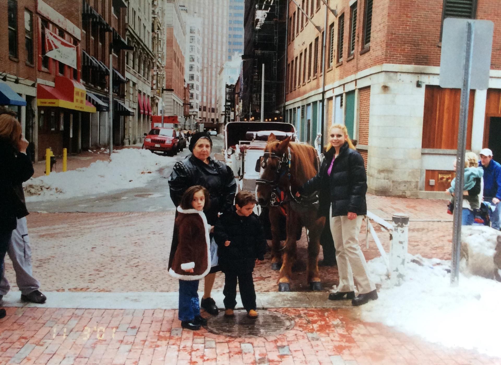 Family photo of three children with elderly woman outdoors in city street