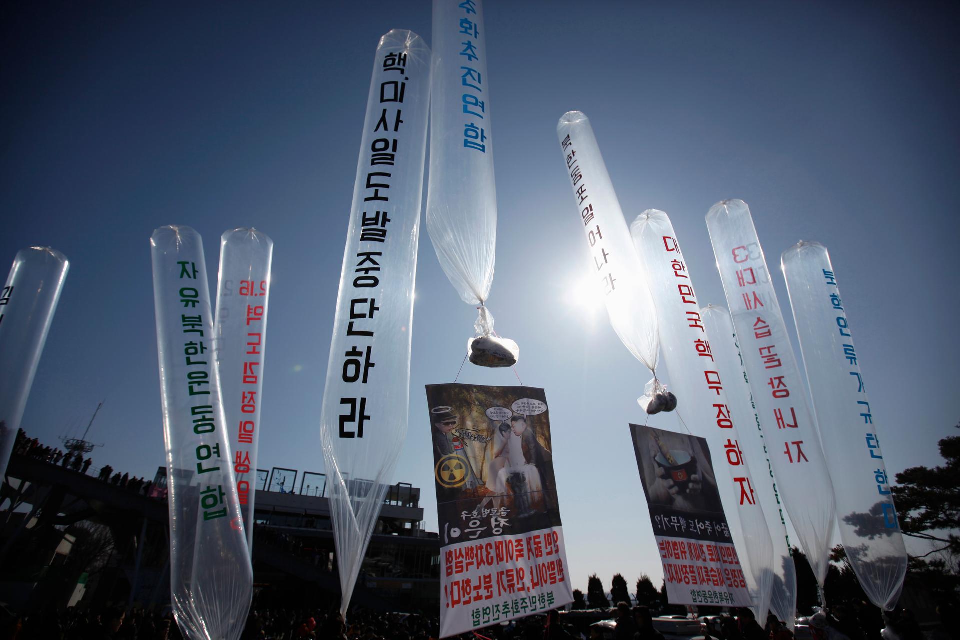North Korean defectors living in South Korea hold balloons containing leaflets and CDs