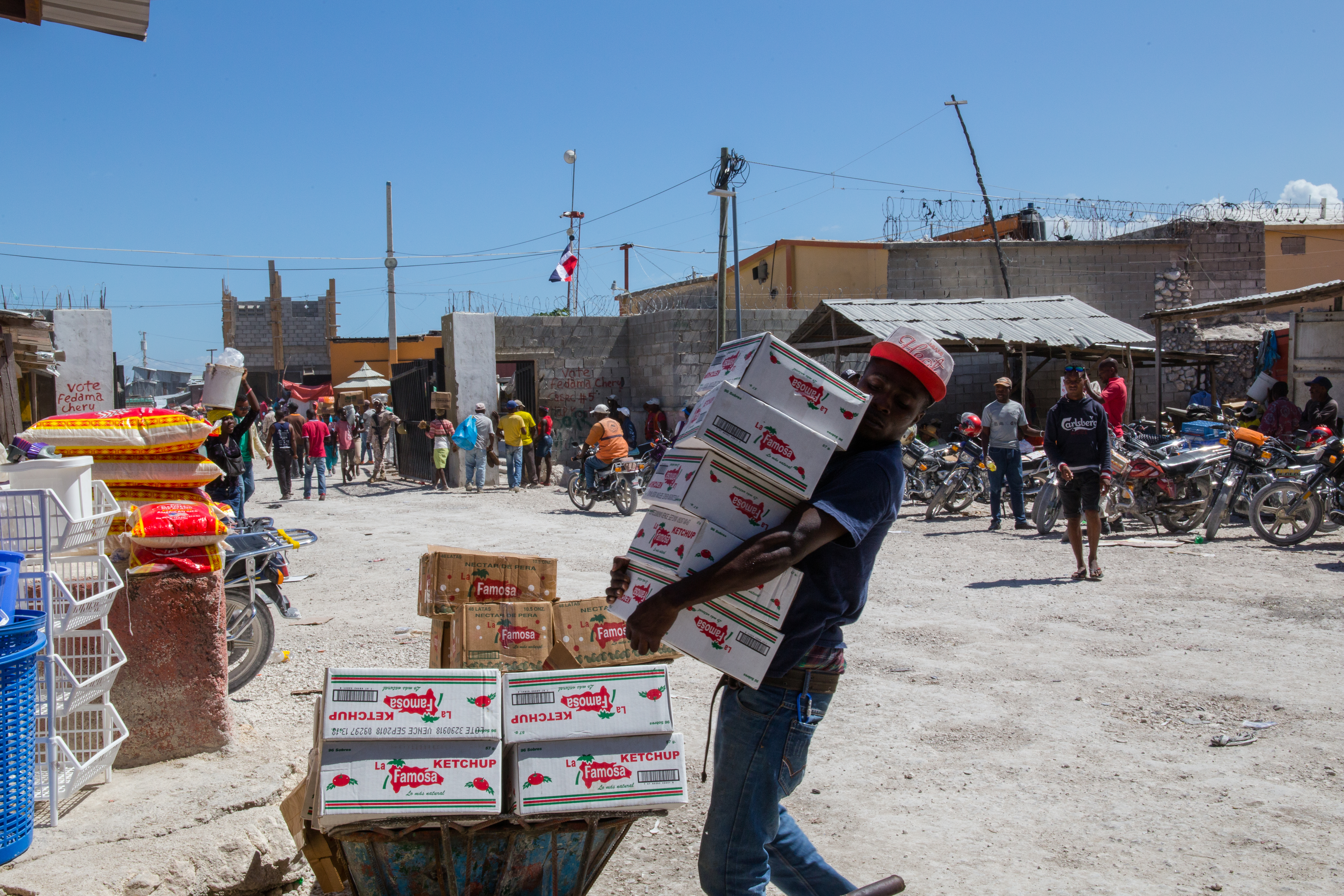 A man loads up a wheelbarrow with Dominican catsup on the Haitian side of the border.