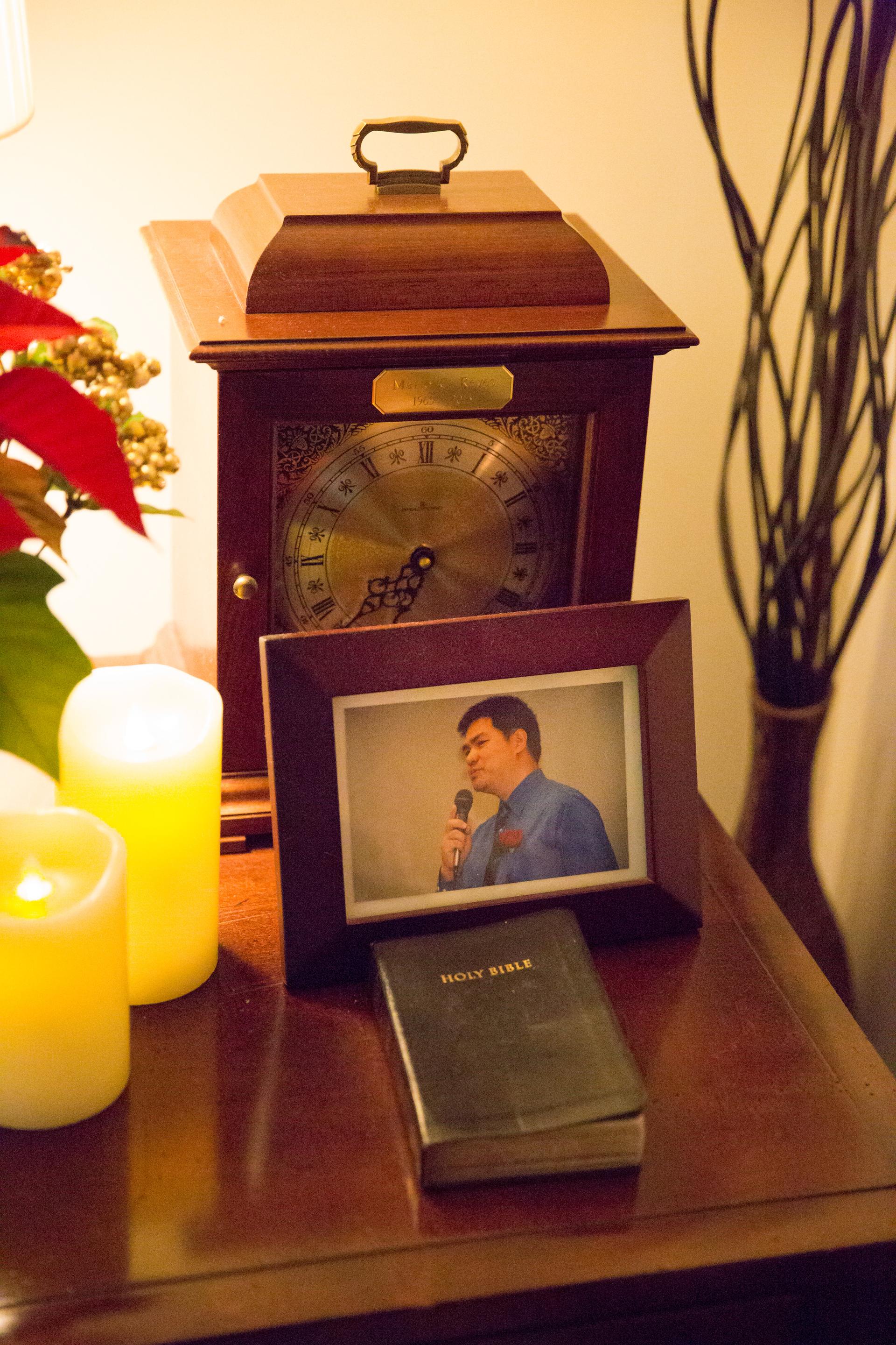 A framed photo is on top of a table with an unopened bible.