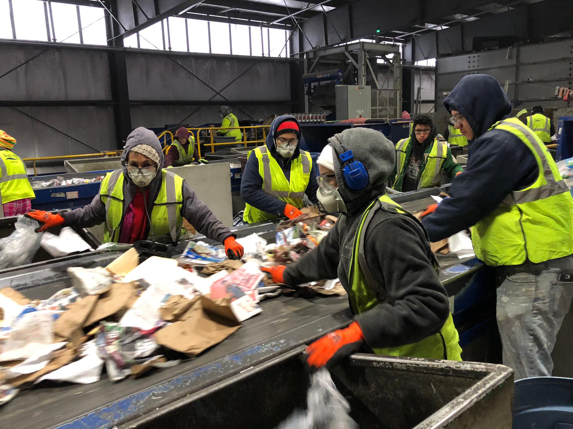 Workers manually sort trash from recycling at E.L. Harvey & Sons. Approximately 15 percent of the recycling that’s collected here is unusable trash.
