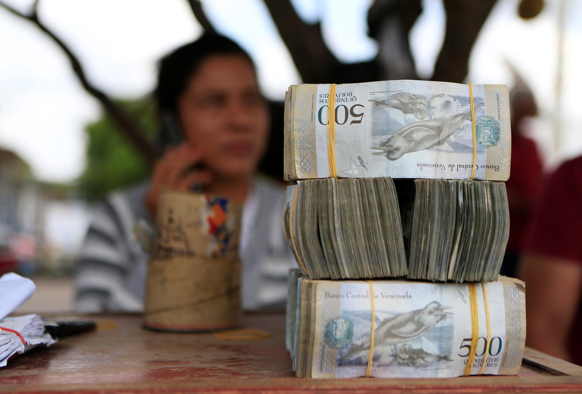 A money changer sits at a table at the border between Colombia and Venezuela, in Paraguachón, Colombia, Feb. 16, 2018.