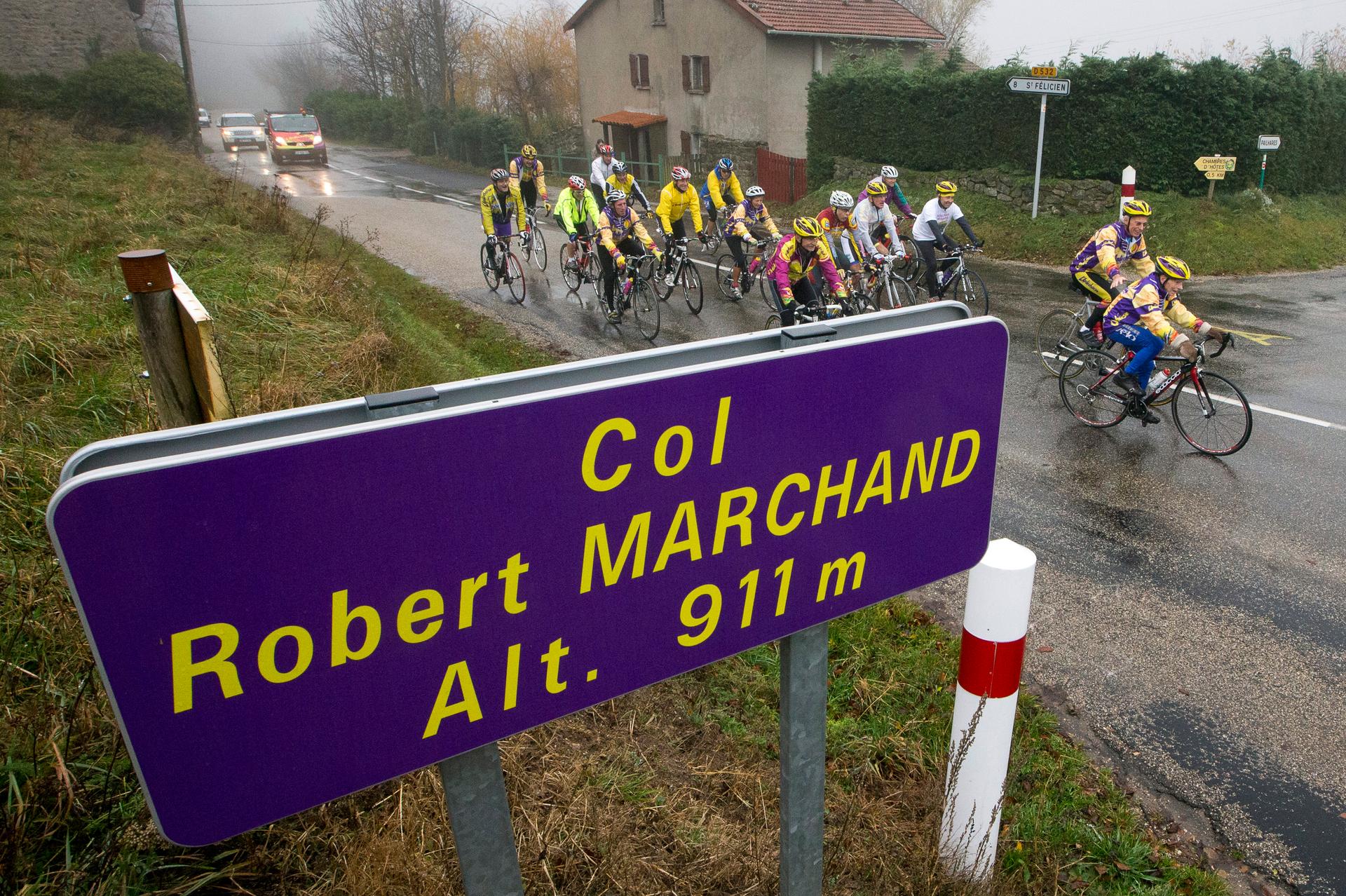 Robert Marchand (R), 103 years-old, cycles in the rain ahead of a small group of riders to celebrate his birthday as he makes his way along the Robert Marchand pass