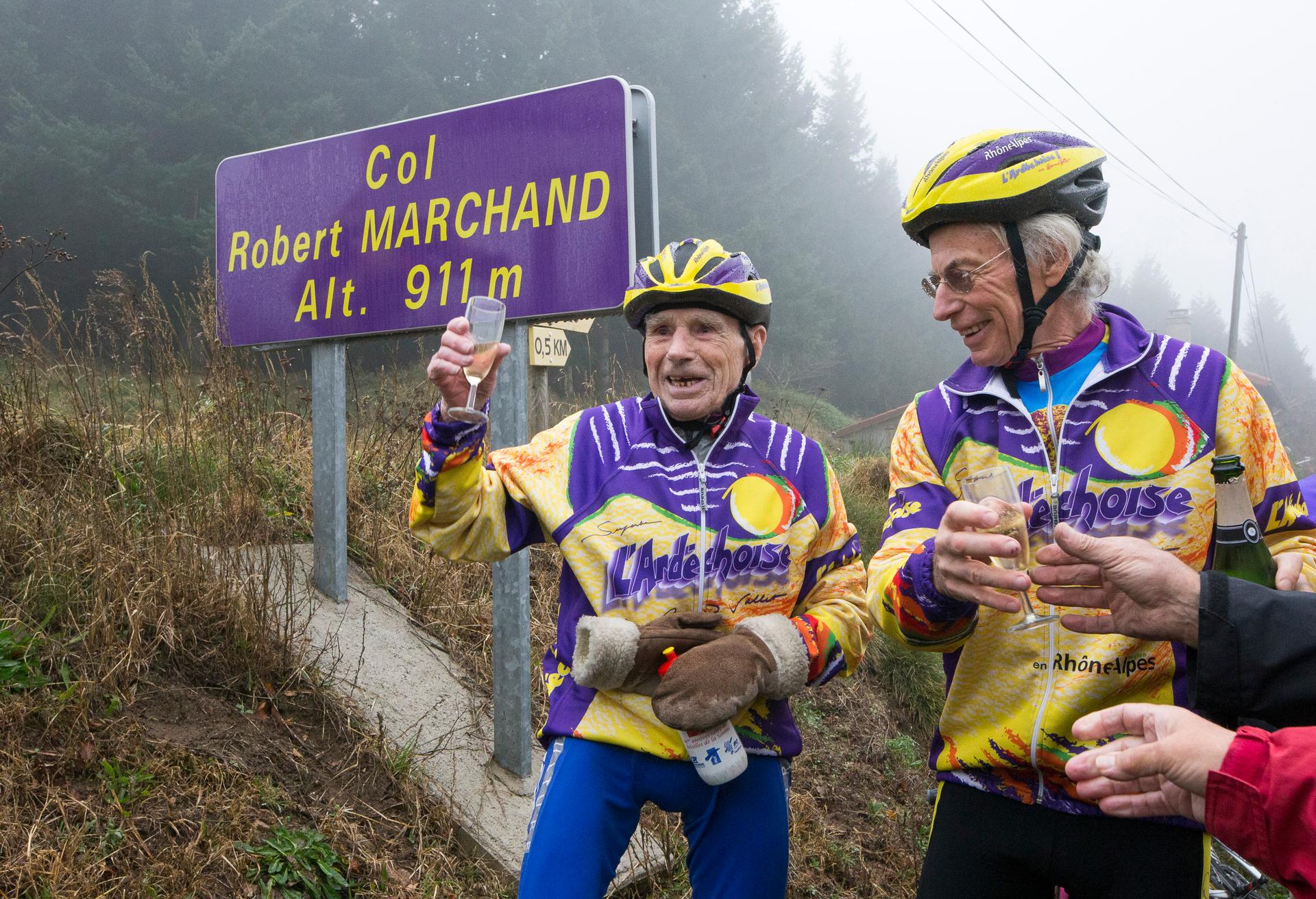 French cyclist Robert Marchand (L), raises a glass of champagne to celebrate his 103rd birthday