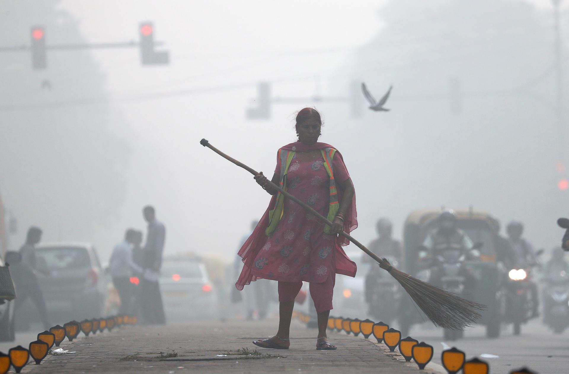 A street cleaner works in heavy smog in Delhi, India, Nov. 10, 2017.