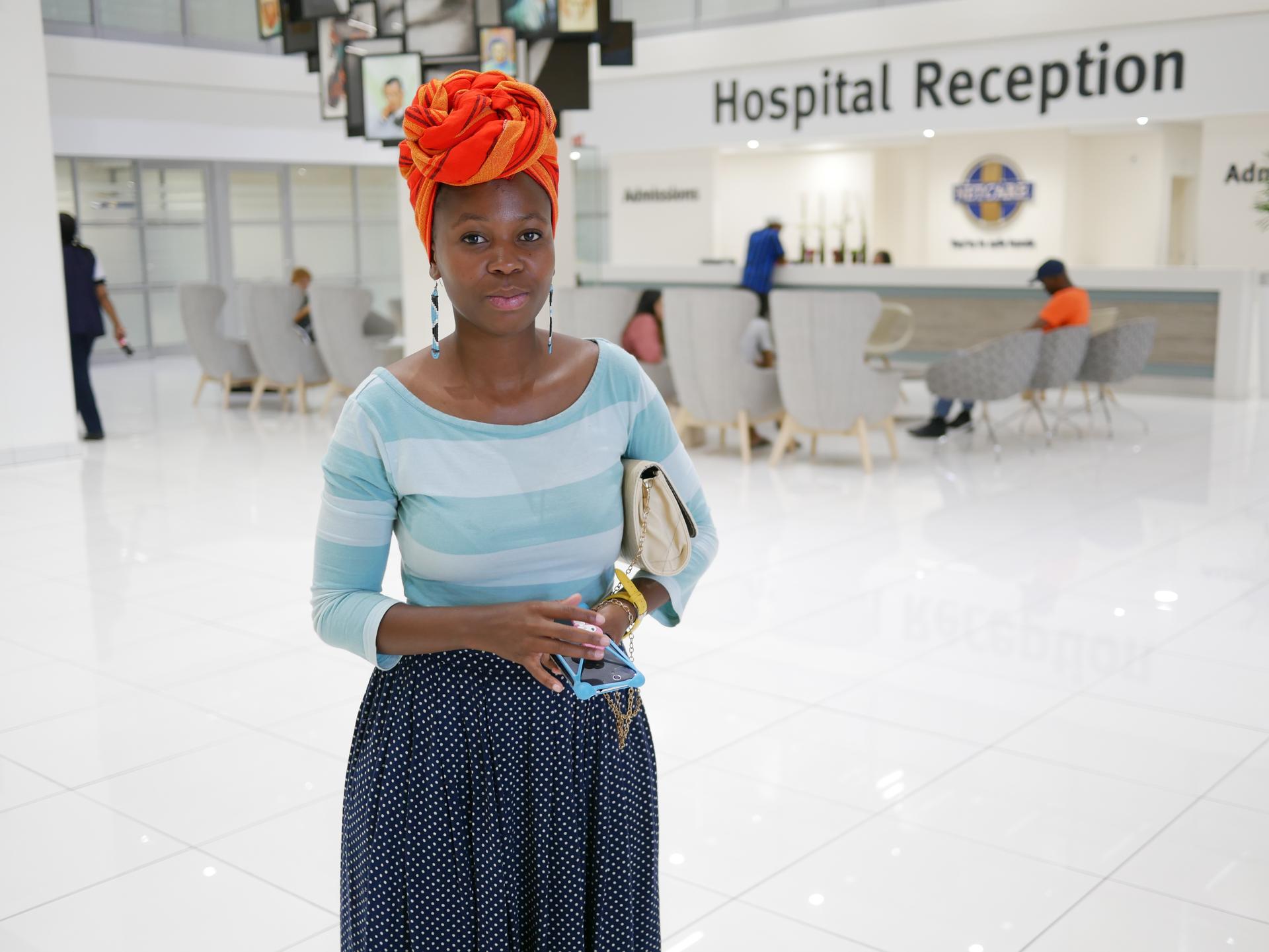 Somila Makangume, a Cape Town resident, in an orange head wrap and blue striped shirt, at Christiaan Barnard Hospital.
