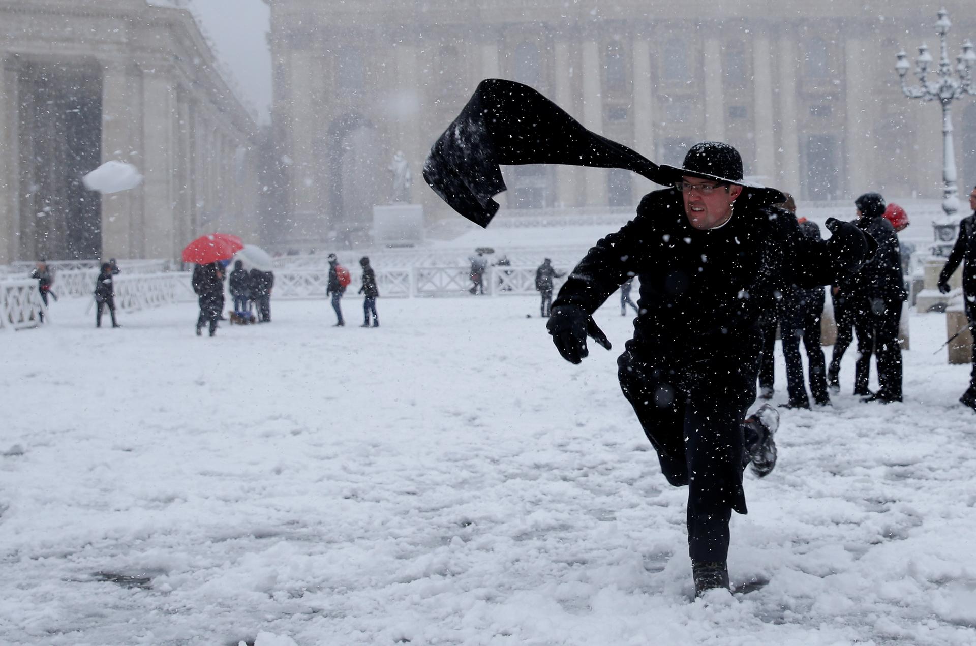 A priest plays with snow during a heavy snowfall in Saint Peter's Square at the Vatican on February 26.