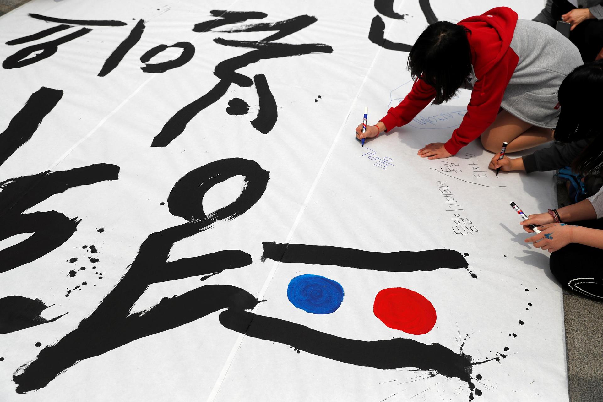 People write goodwill messages during a pro-unification rally