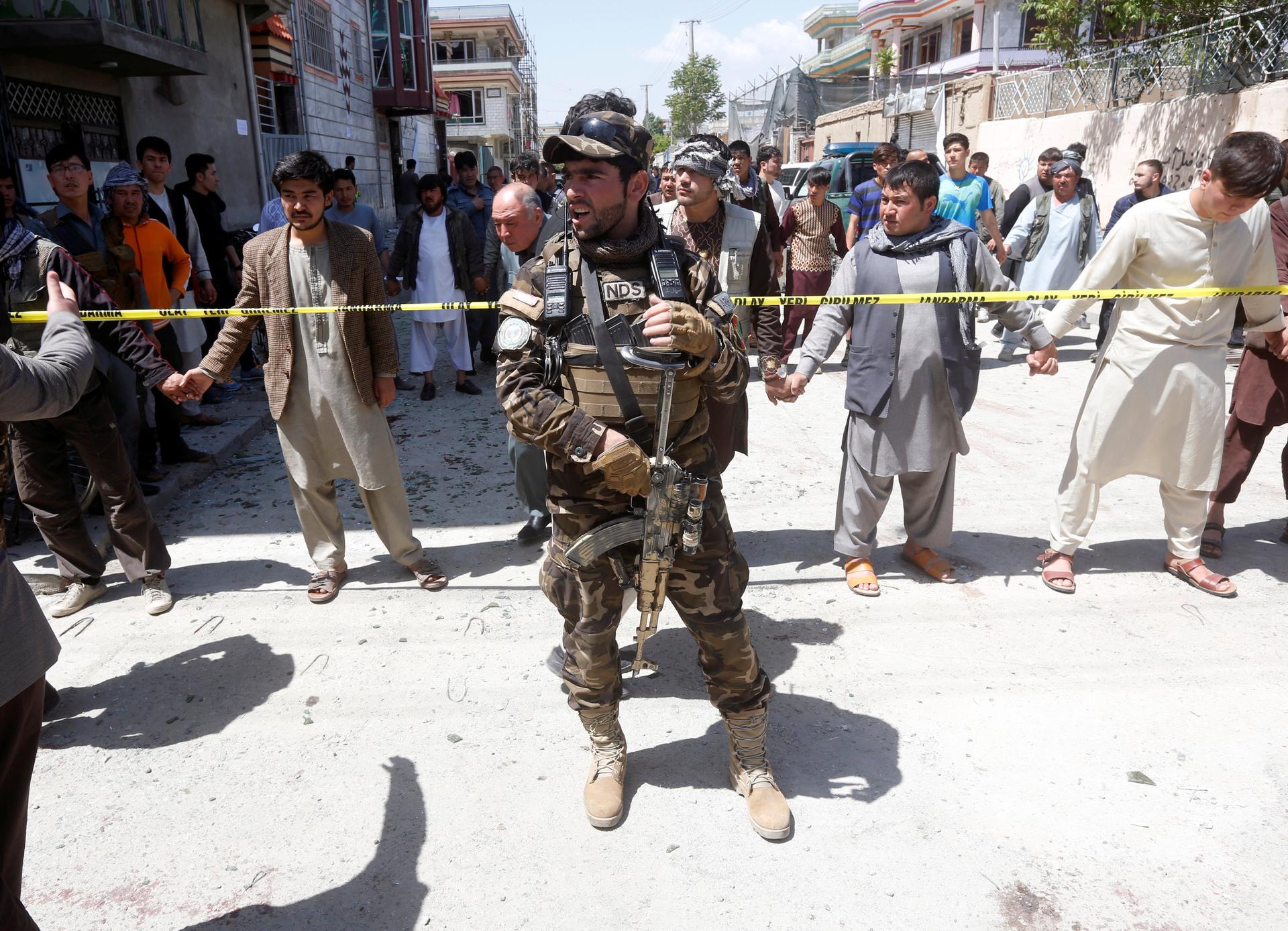An Afghan security forces member stands guard at the site of a suicide bomb attack in Kabul.