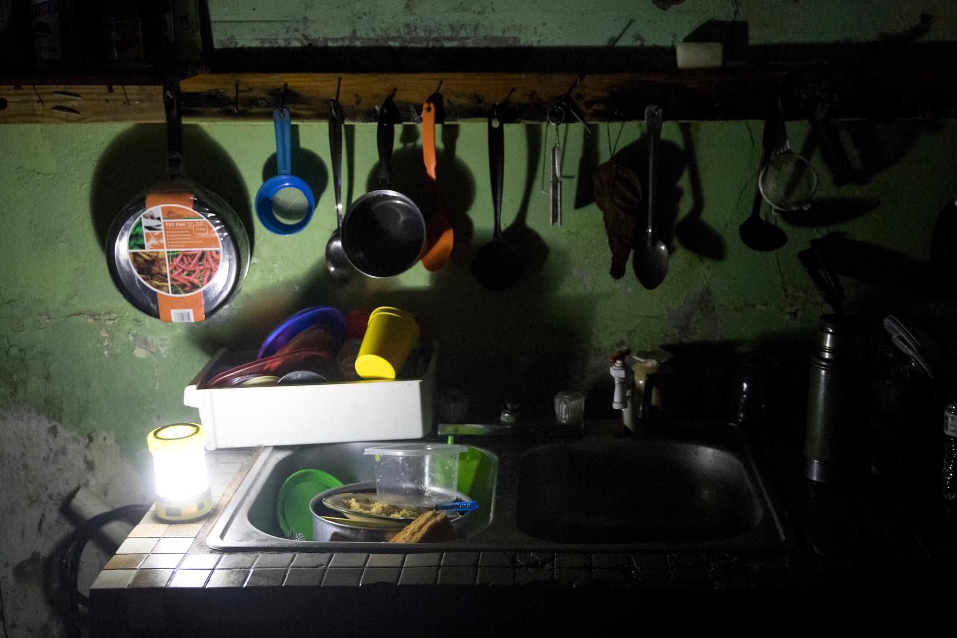 The kitchen of Irma Torres and her husband Jose Morales is lit by a battery-powered lantern
