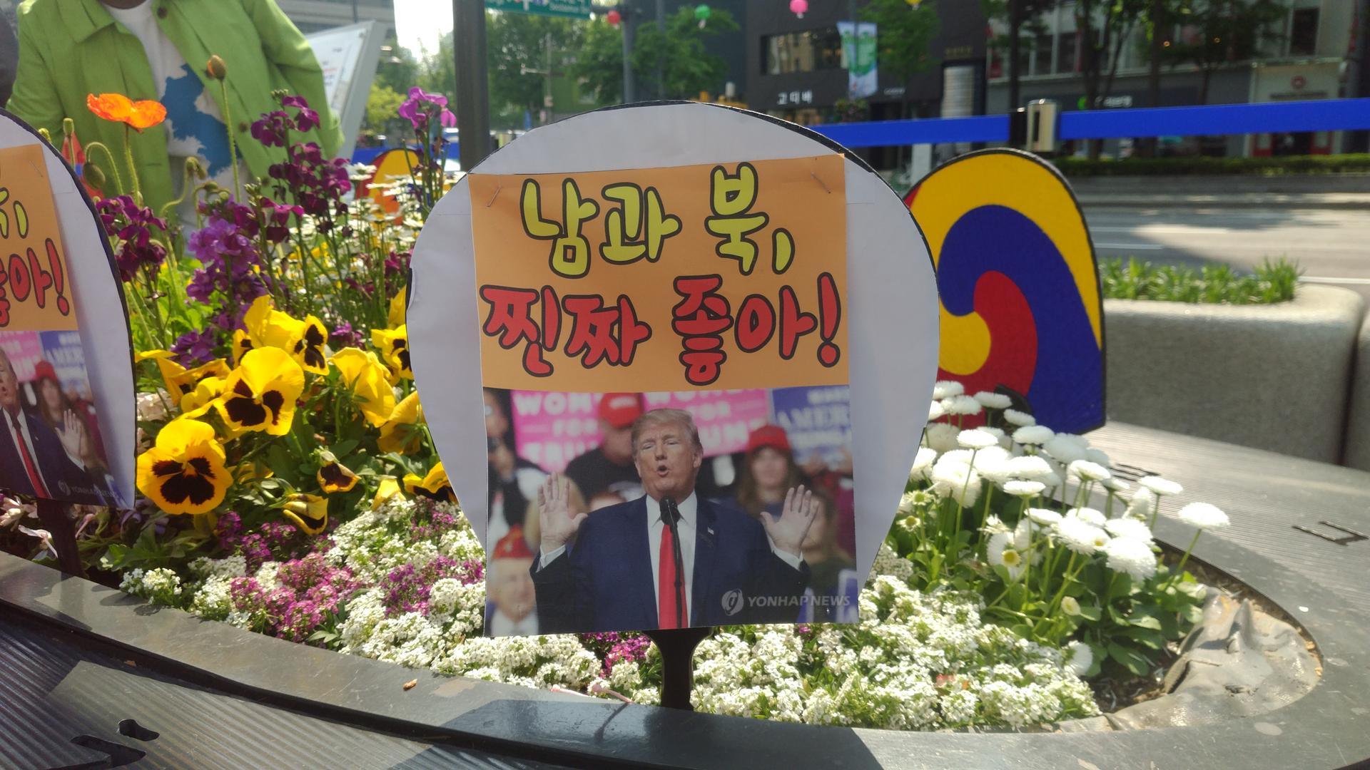 Demonstrators for peace planted signs depicting U.S. President Donald Trump saying 