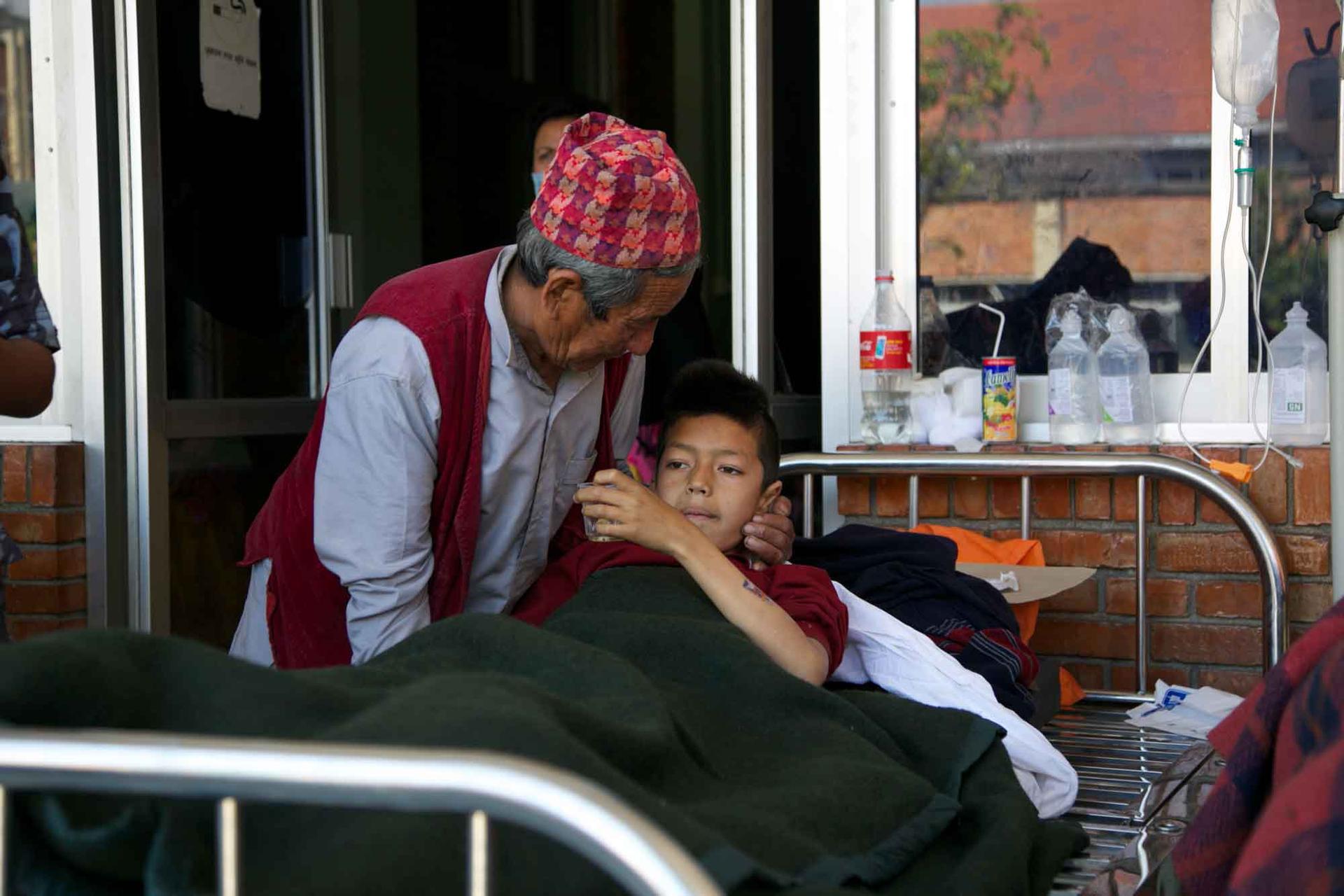A father comforts his son as he gets a shot at Tribhuvan University Teaching Hospital.