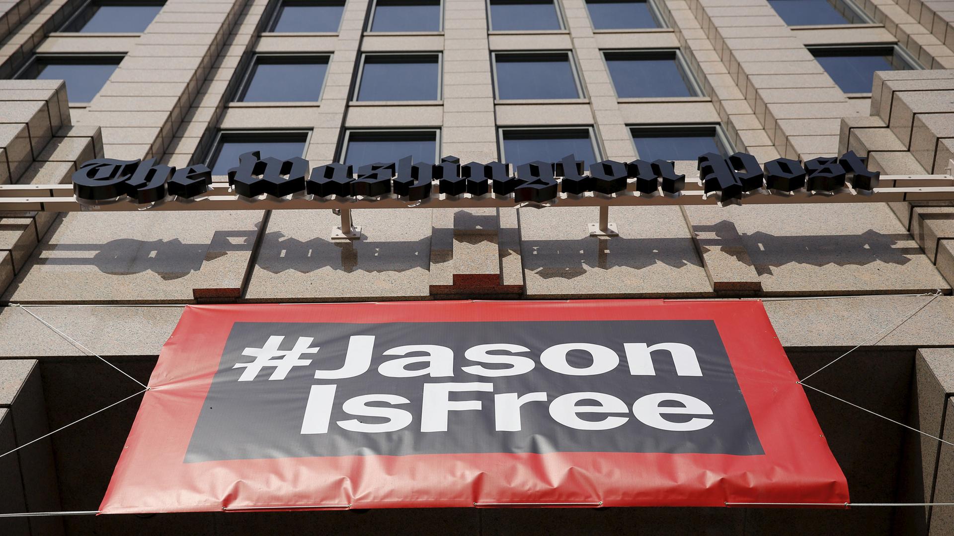 A large banner hangs below the Washington Post building reading #JasonisFree