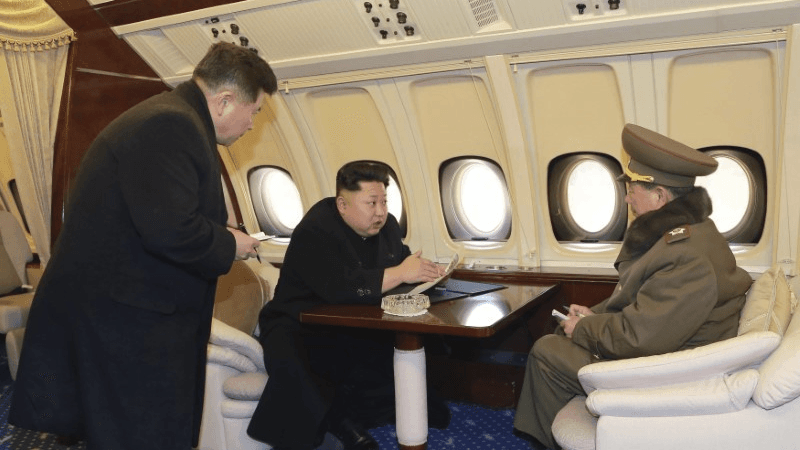 North Korean leader Kim Jong-un (C) talks with officials onboard his personal plane in this undated photo released by North Korea's Korean Central News Agency (KCNA) in Pyongyang Feb. 15, 2015. 