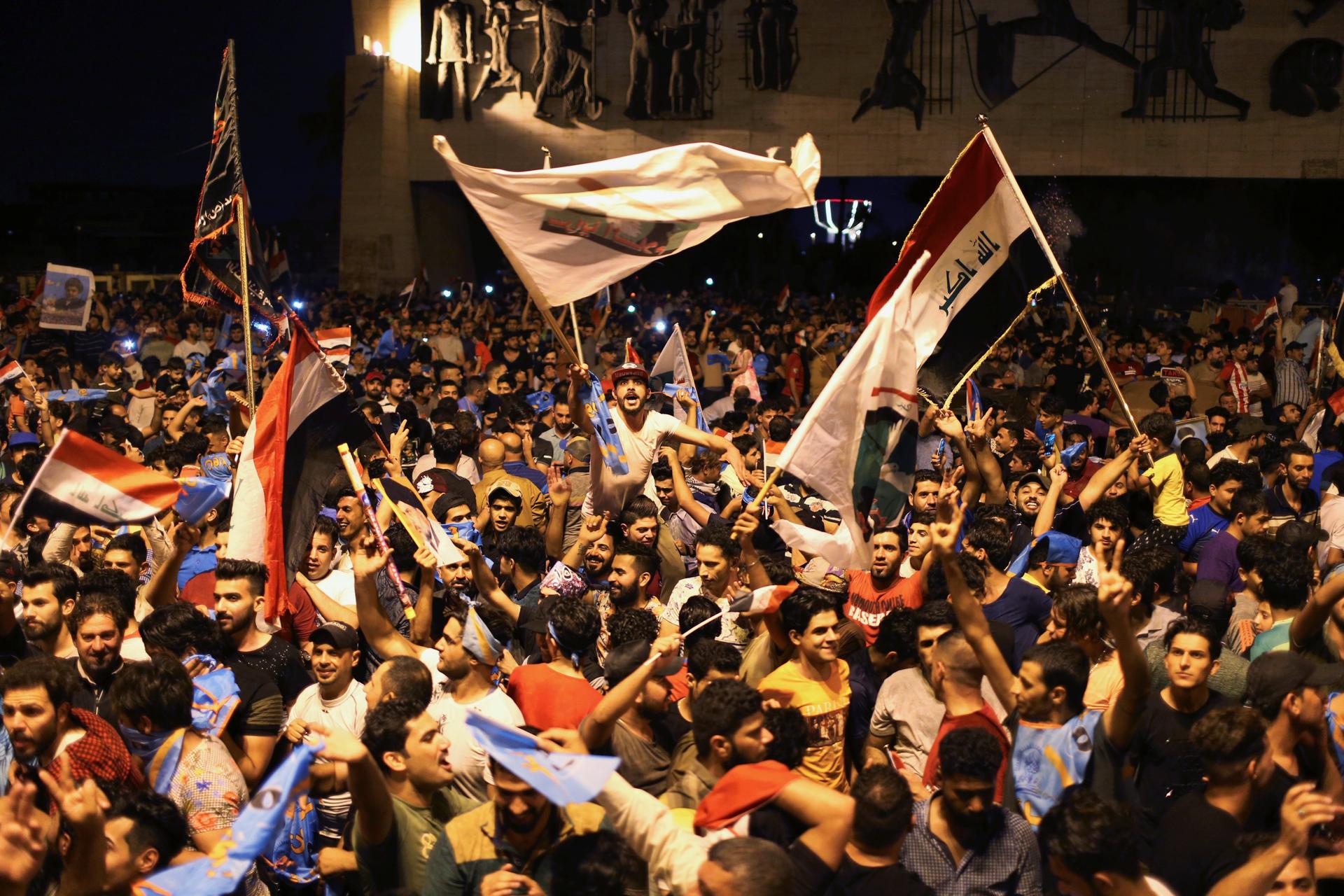 Iraqi supporters of cleric Moqtada al-Sadr's Sairun coalition celebrate after results of Iraq's parliamentary election were announced in Baghdad, Iraq, on May 14, 2018.