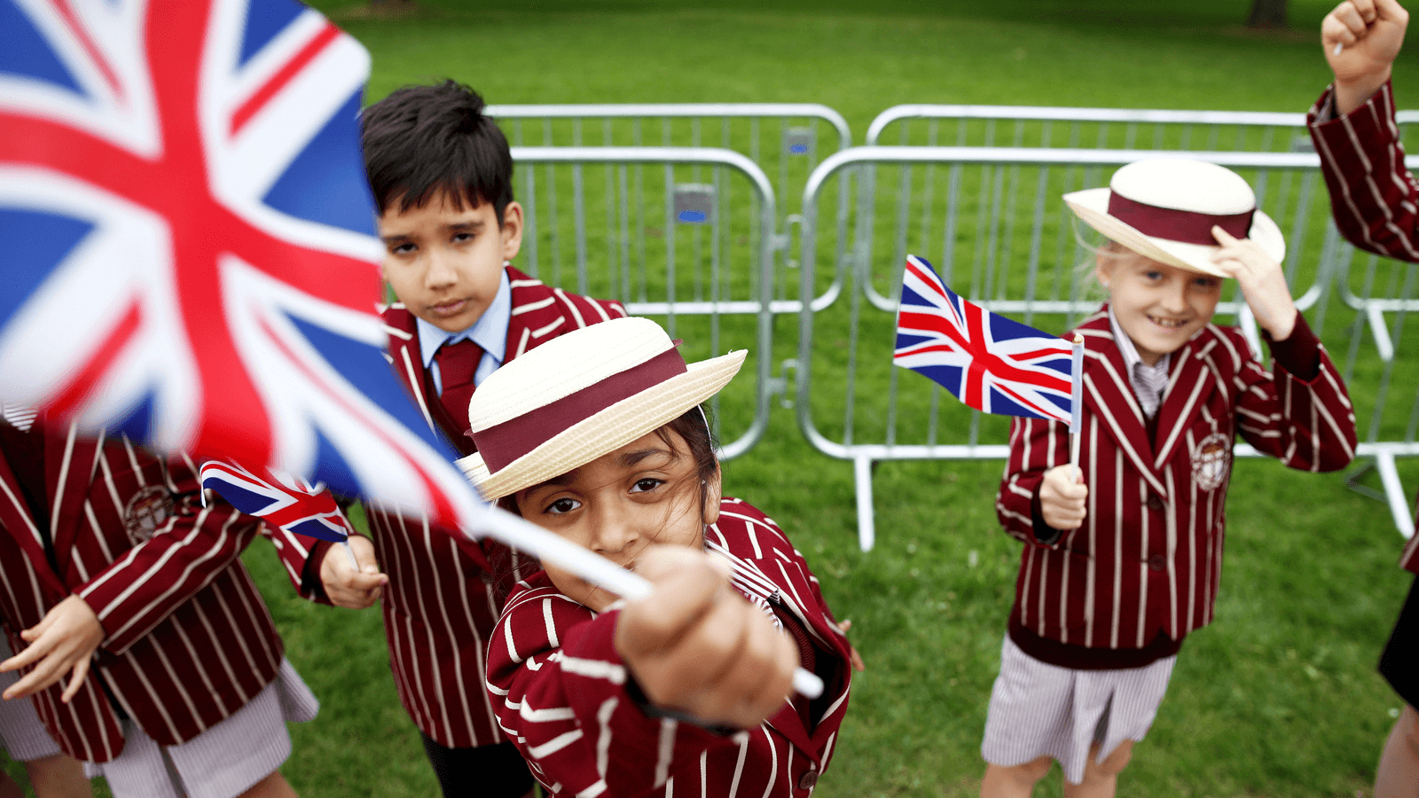 Schoolchildren wave British flags in a garden just days before the next royal wedding.