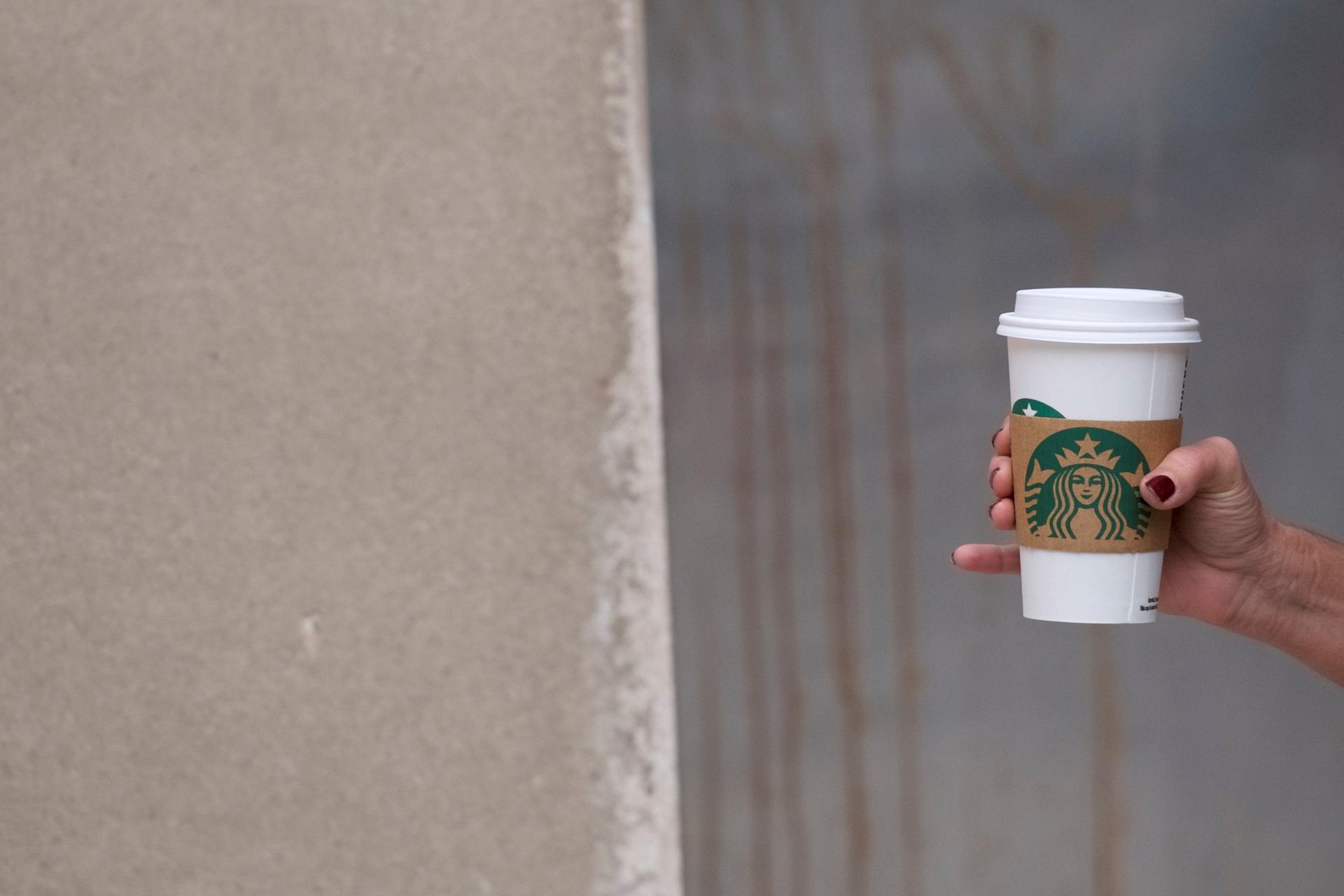 A woman walks through Center City in  Philadelphia, Pennsylvania, clutching a hot Starbucks beverage