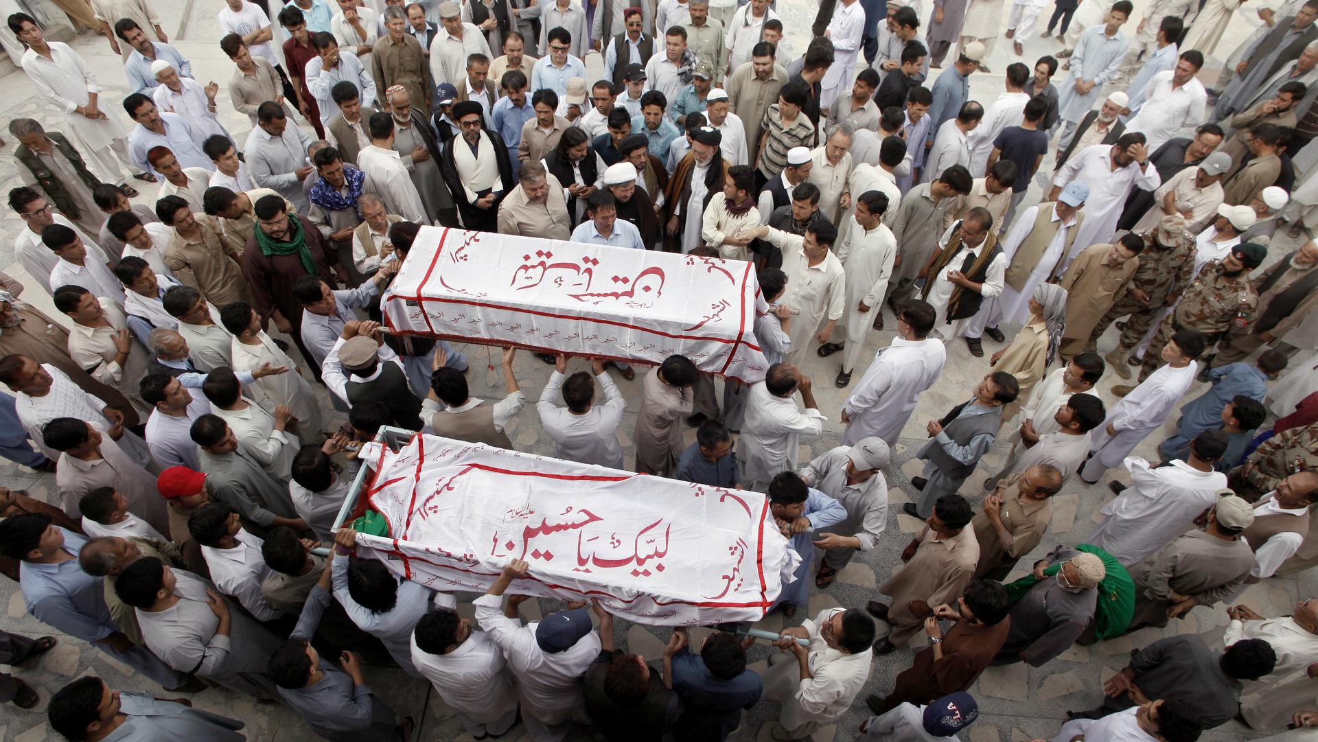Hazara men carry the coffins of their relatives who were killed after gunmen opened fire on a car, during a funeral ceremony in Quetta, Pakistan, July 19, 2017.