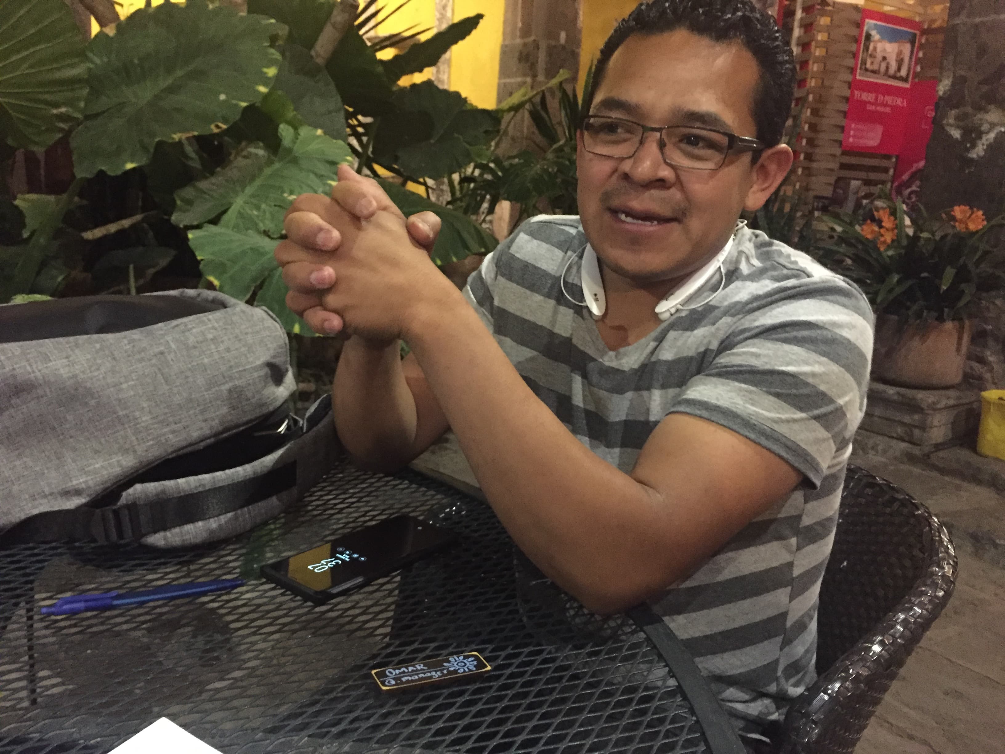 Man sitting at table outdoors, with phone in front of him