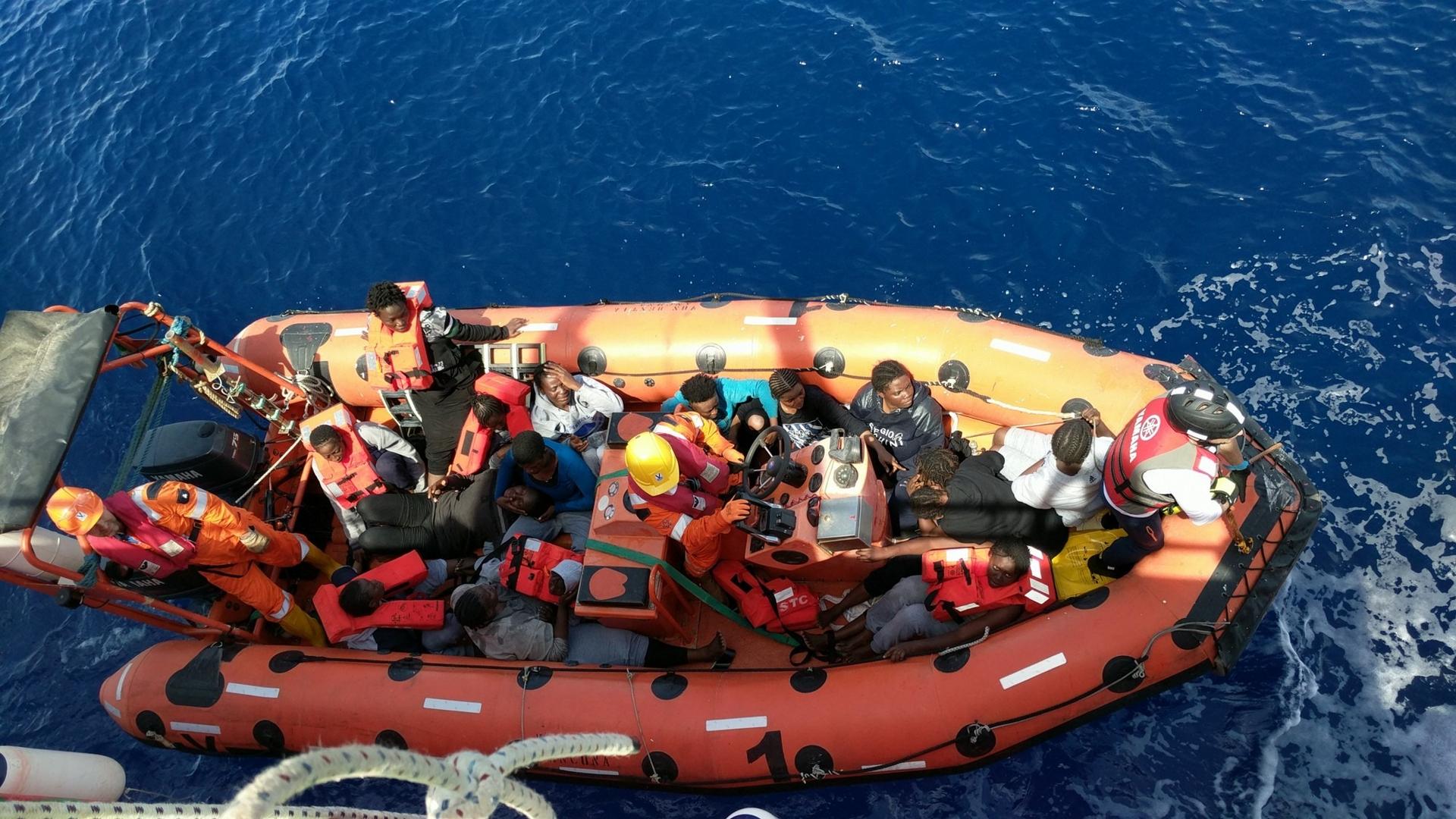 Migrants are brought aboard a Save the Children rescue boat
