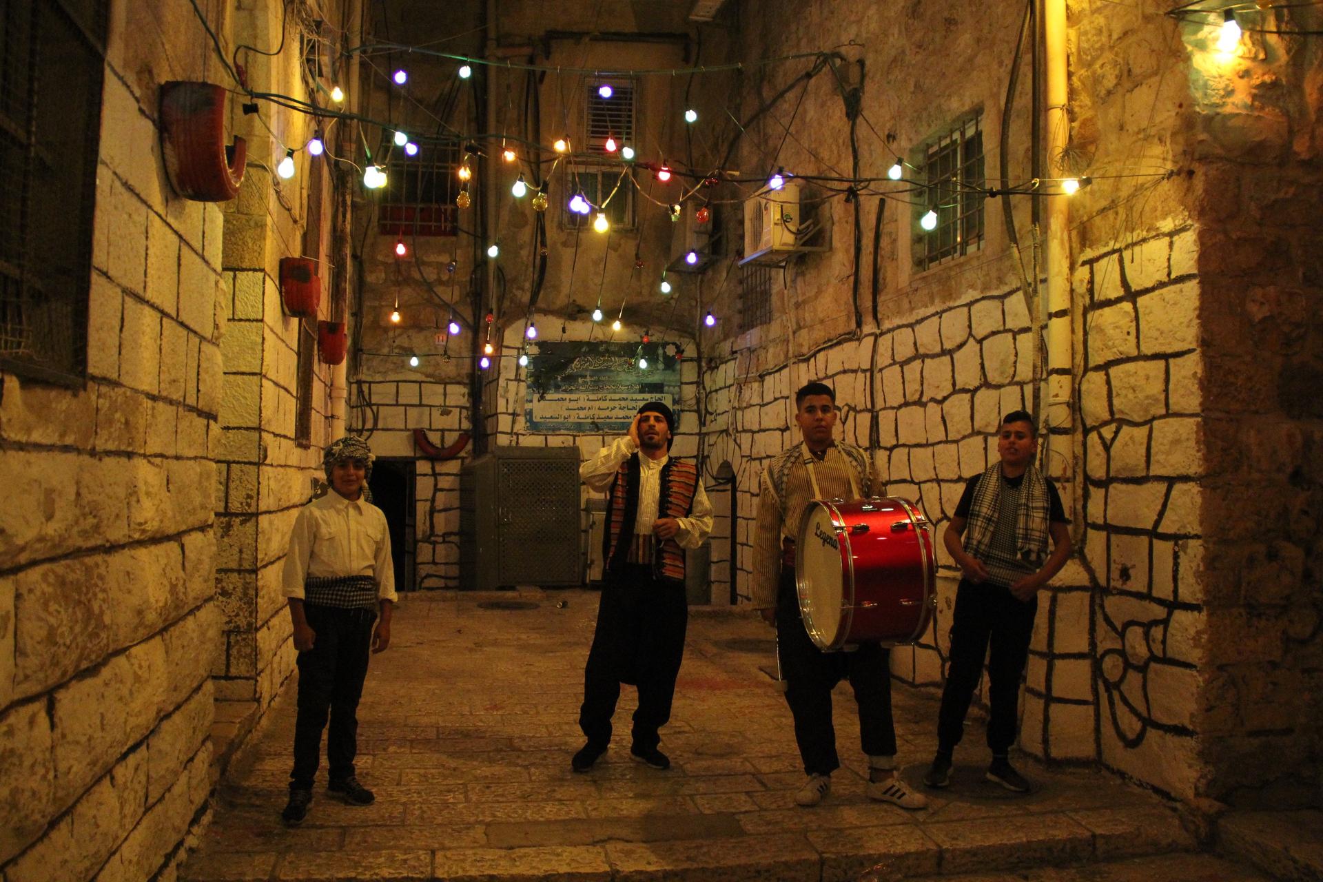 Young Palestinians in Jerusalem's Old City volunteer as public wakers, called musaharati, to sing and drum in city streets during Ramadan