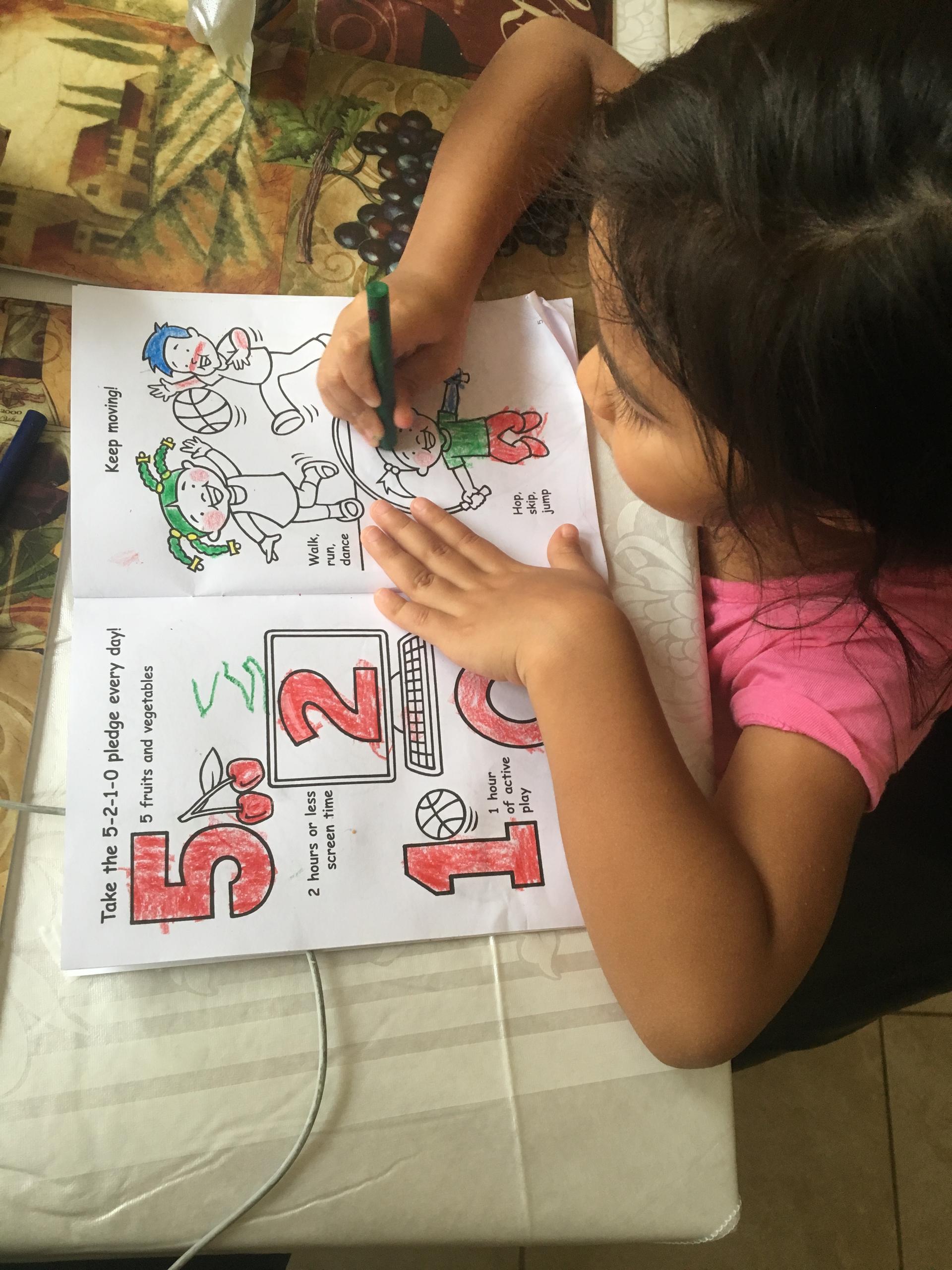 overhead view of young girl coloring in coloring book