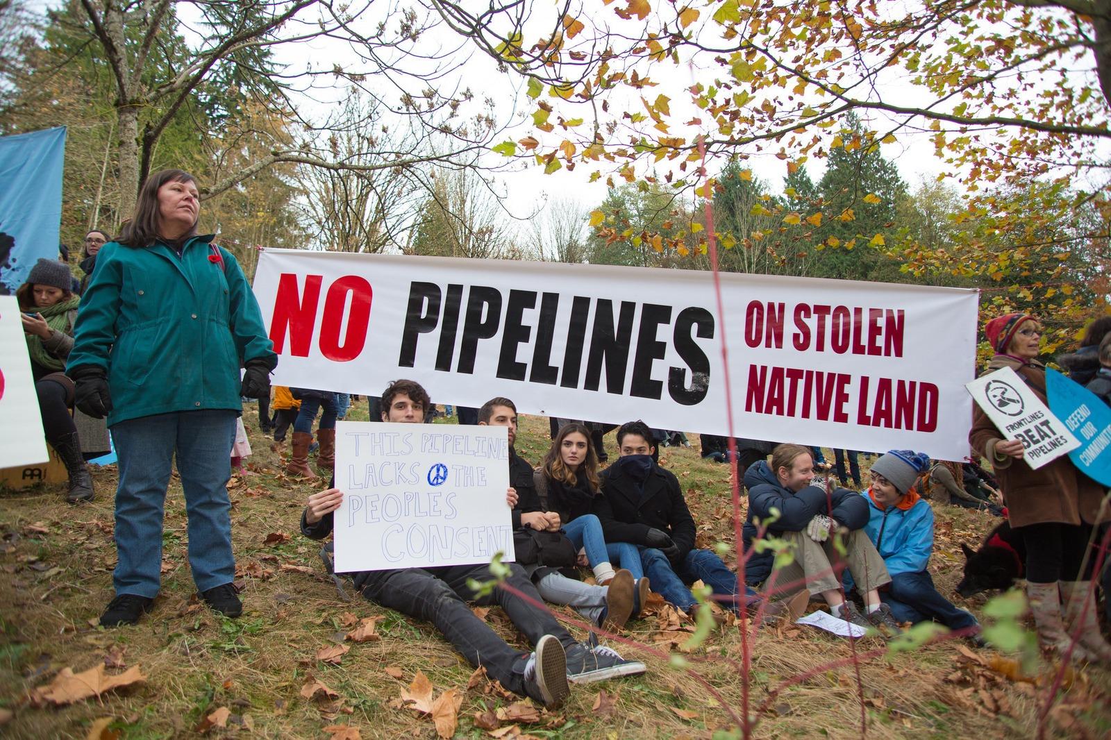 Protestors hold up signs at a rally against a proposed Kinder Morgan oil pipeline expansion on Burnaby Mountain in 2014 in British Columbia. In late May, the Canadian government announced it would fund an expansion project for the Kinder Morgan Trans Moun