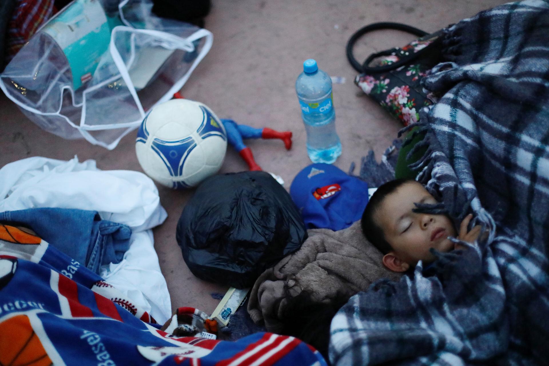 A child traveling with a caravan of migrants from Central America sleeps 