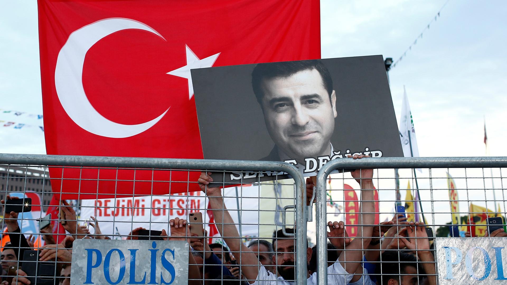 A supporter of Turkey's main pro-Kurdish Peoples' Democratic Party holds a portrait of their jailed former leader and presidential candidate Selahattin Demirtaş during a campaign event in Istanbul, Turkey, June 17, 2018. 