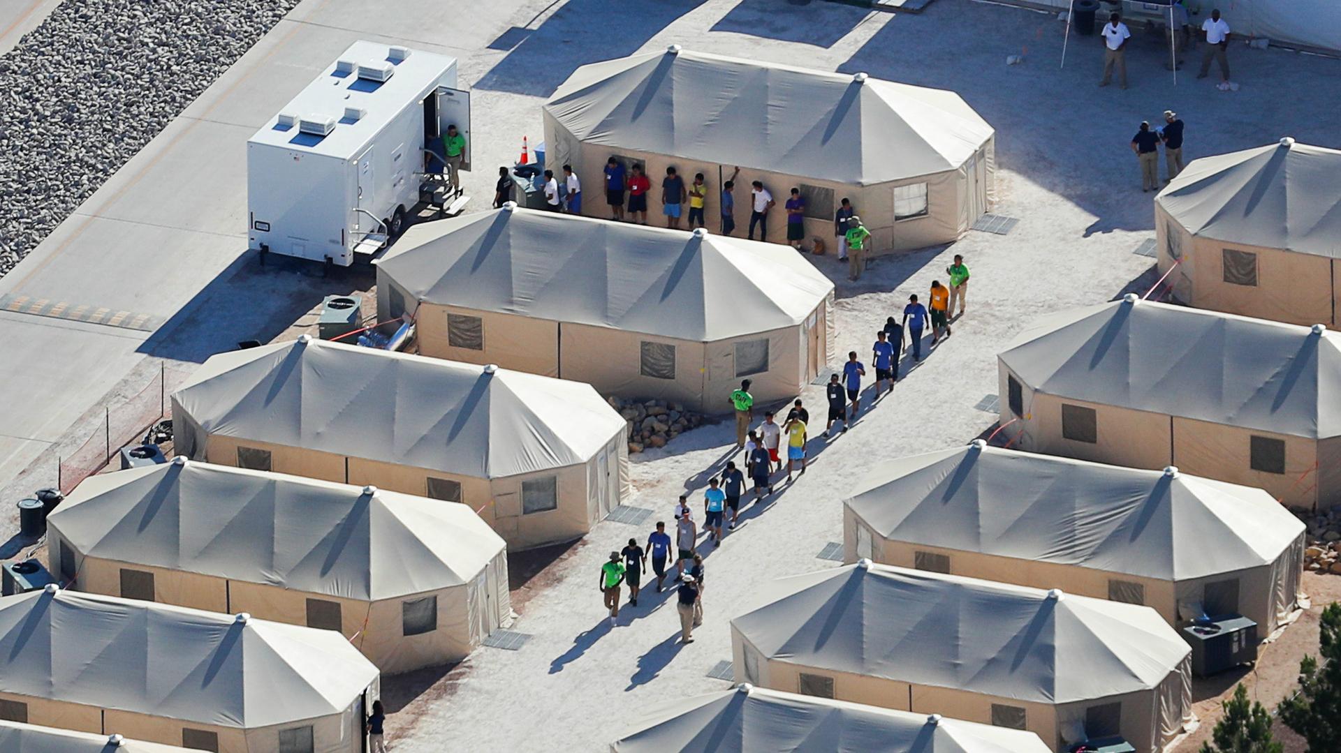 Immigrant children now housed in a tent encampment walk in single file at the facility near the Mexican border in Tornillo, Texas, June 19, 2018.
