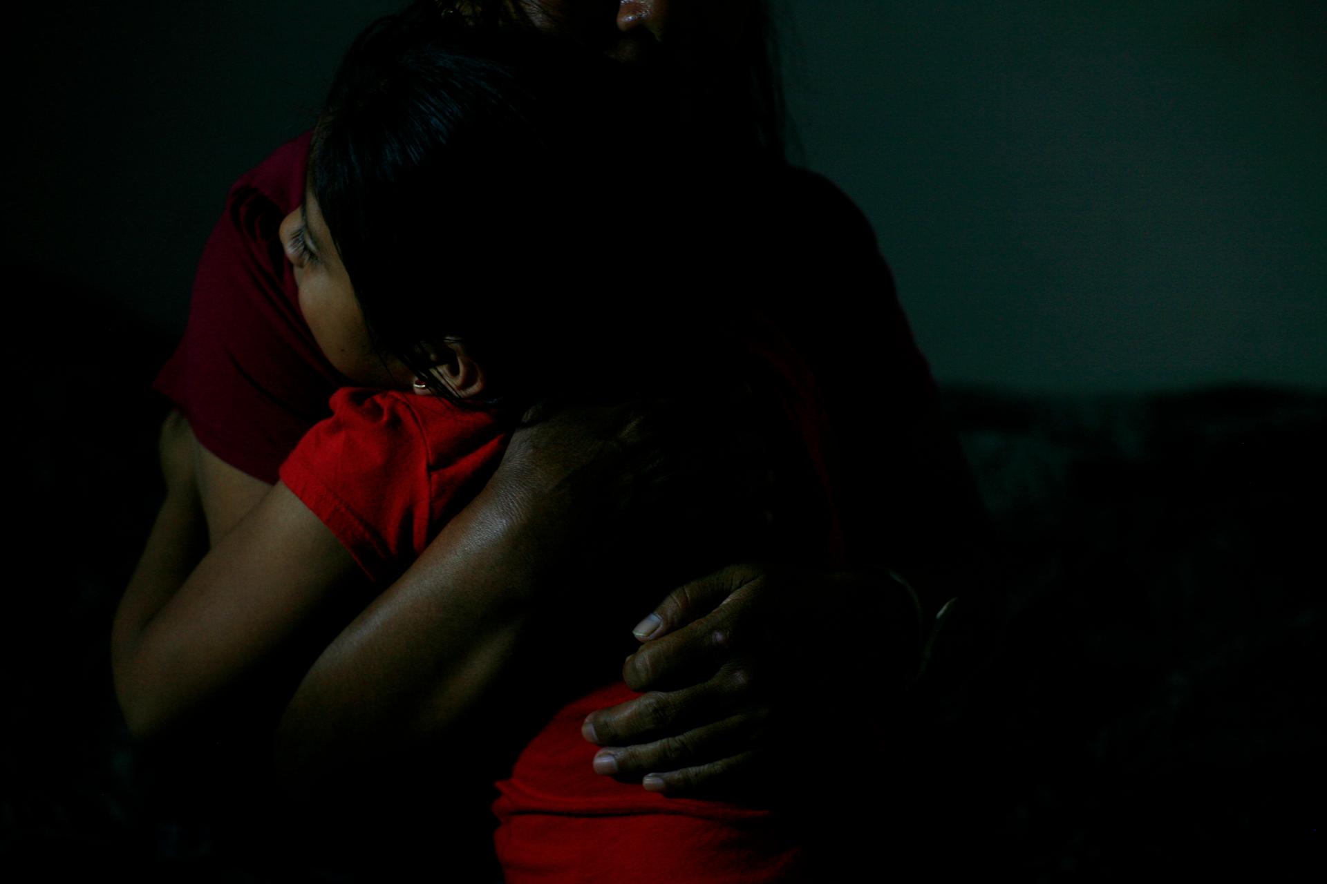 Woman embracing young girl, faces not shown