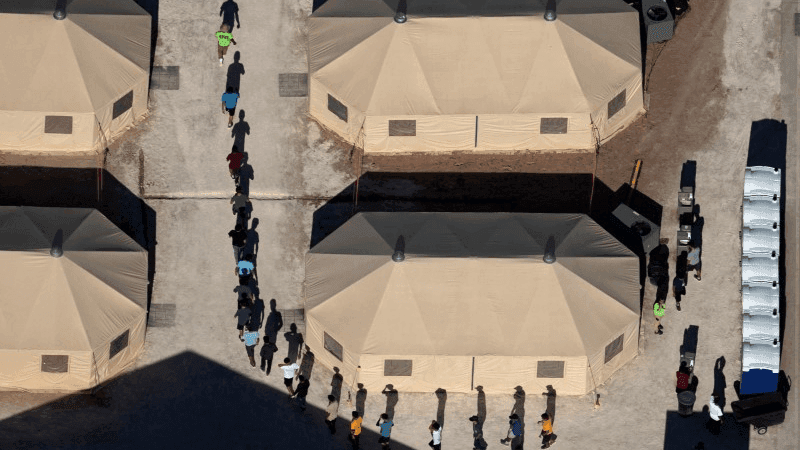 separated migrant children walk in a tent camp in texas
