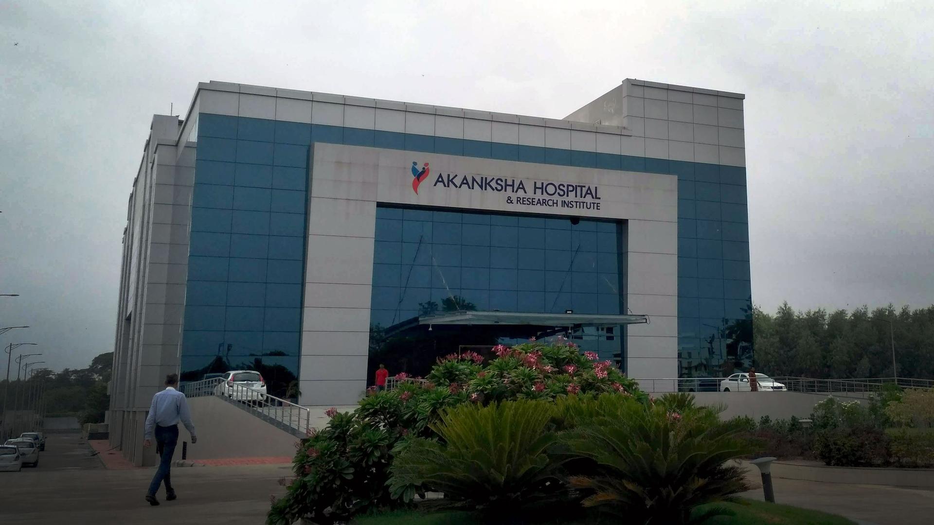 A large hospital building has the sign Akanksah Hospital on the side