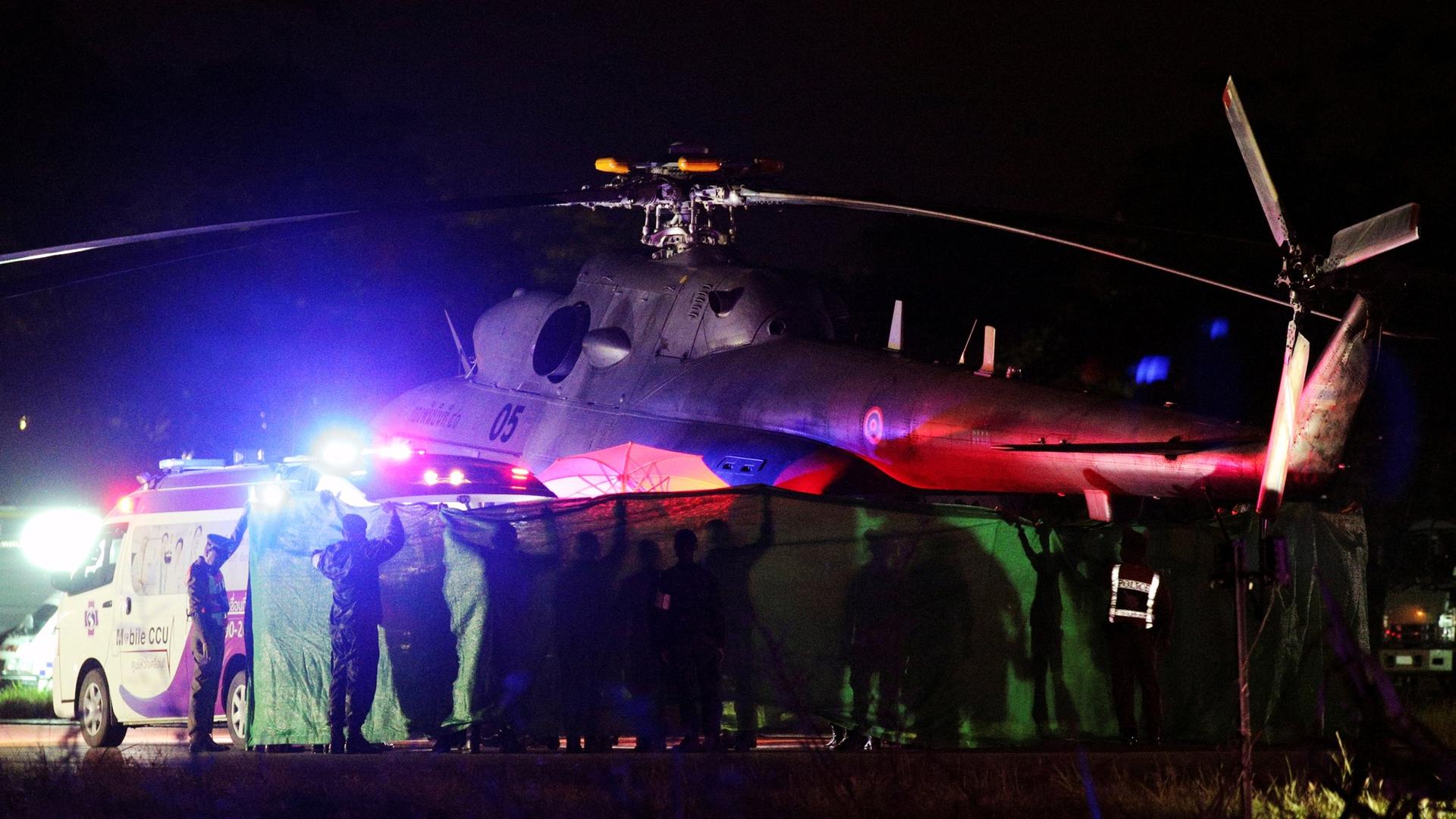 A military helicopter is shown in a photograph taken at night in Chiang Rai, Thailand.
