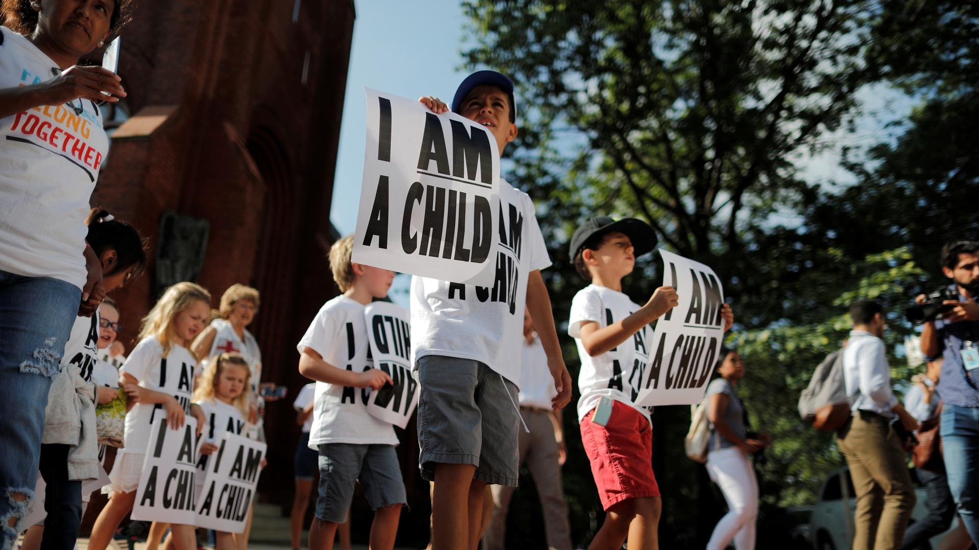 Children carry signs during a protest march in Washington DC, that read 'I am a child.'