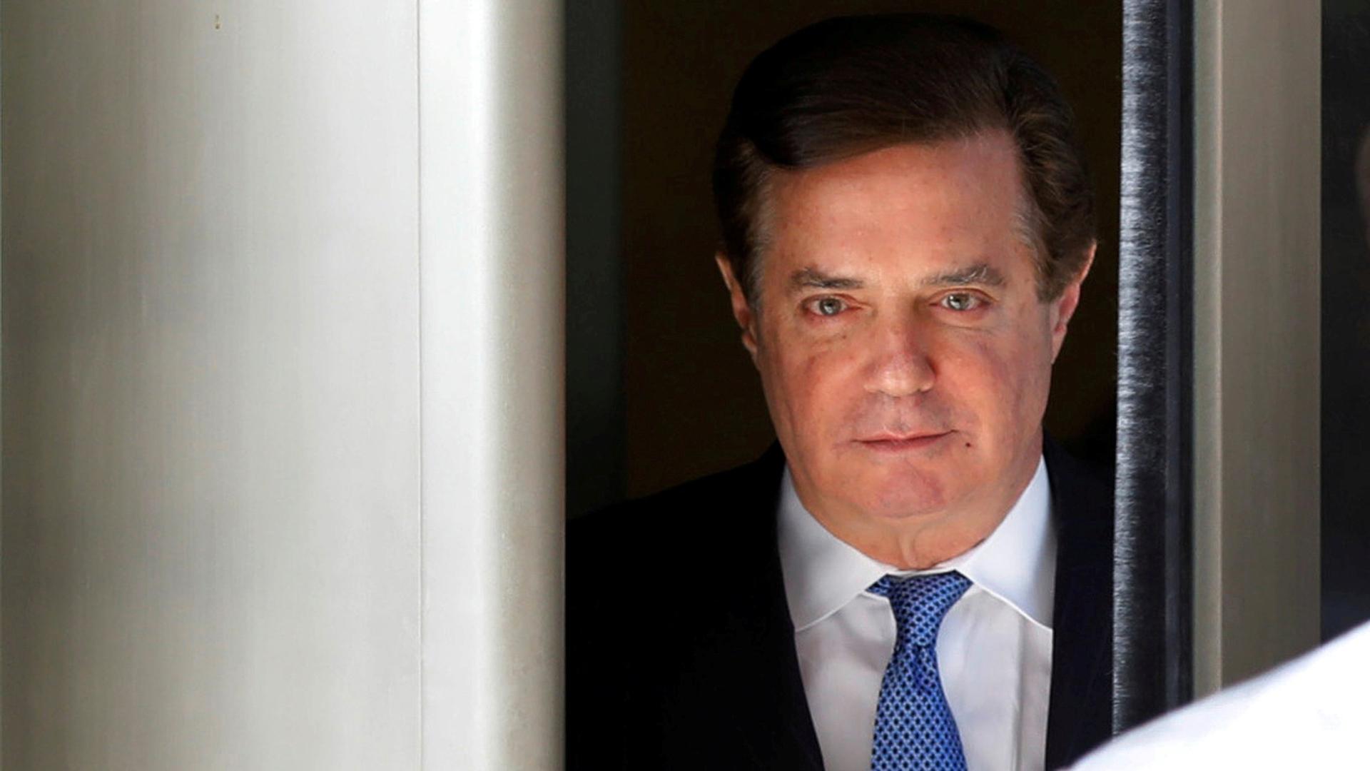 In this close-up photograph, former Trump campaign manager Paul Manafort is seen walking out of the US District Court in Washington DC, dressed in a suit with a blue tie.
