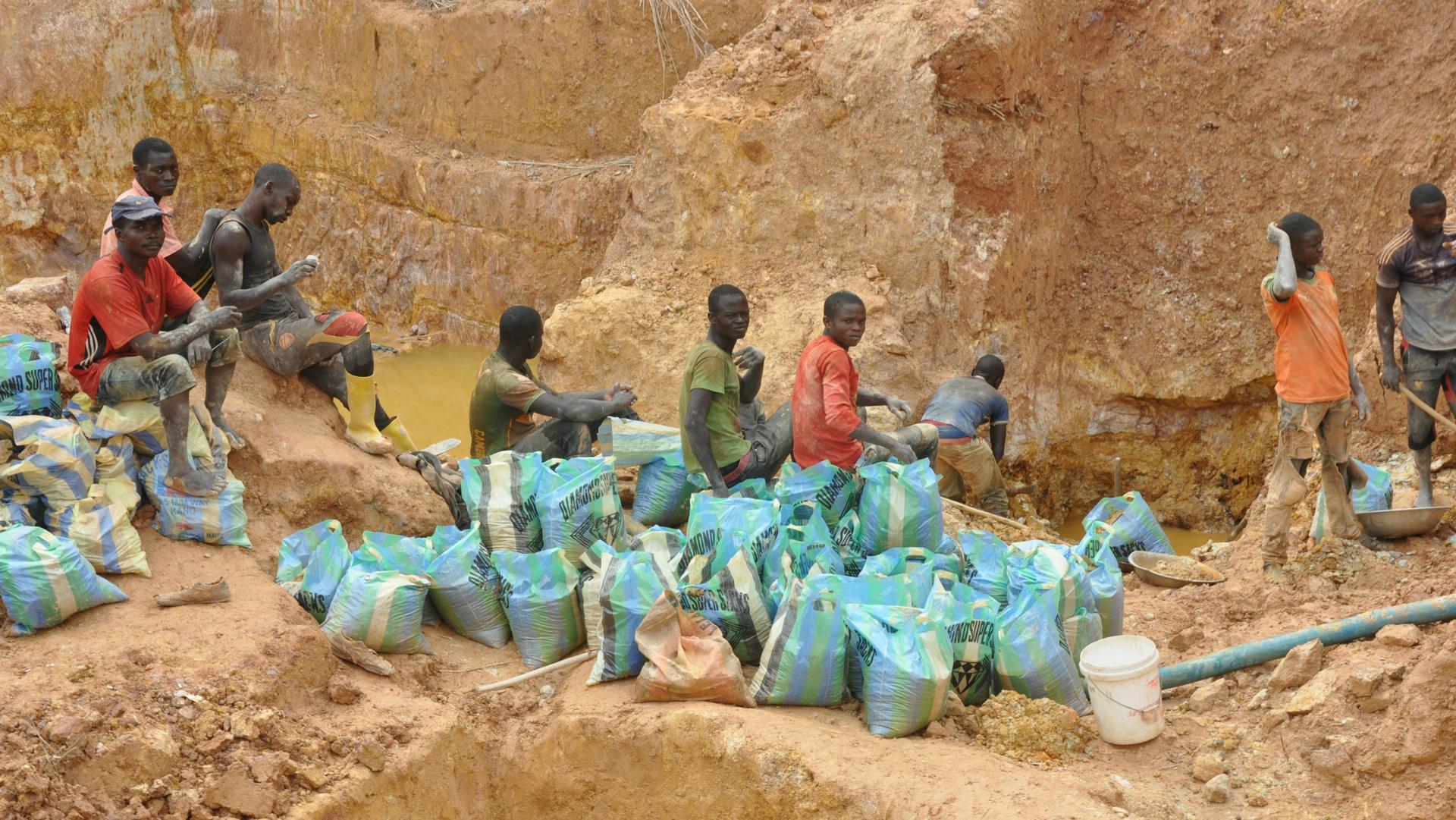 Local miners fill bags with gravel extracted from holes dug by Chinese mining machines in Ngoe Ngoe, Cameroon, Feb. 15, 2018.