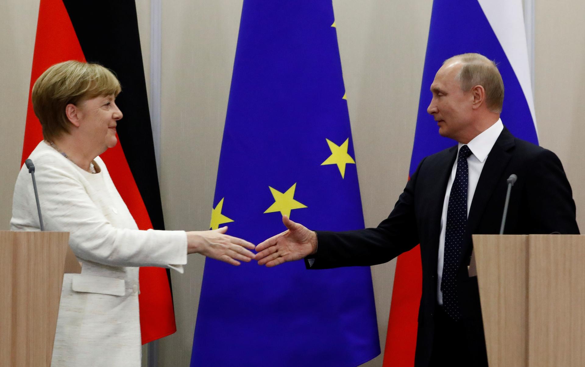 Russian President Vladimir Putin and German Chancellor Angela Merkel shake hands following a joint news conference in the Black Sea resort of Sochi, Russia, May 18, 2018.