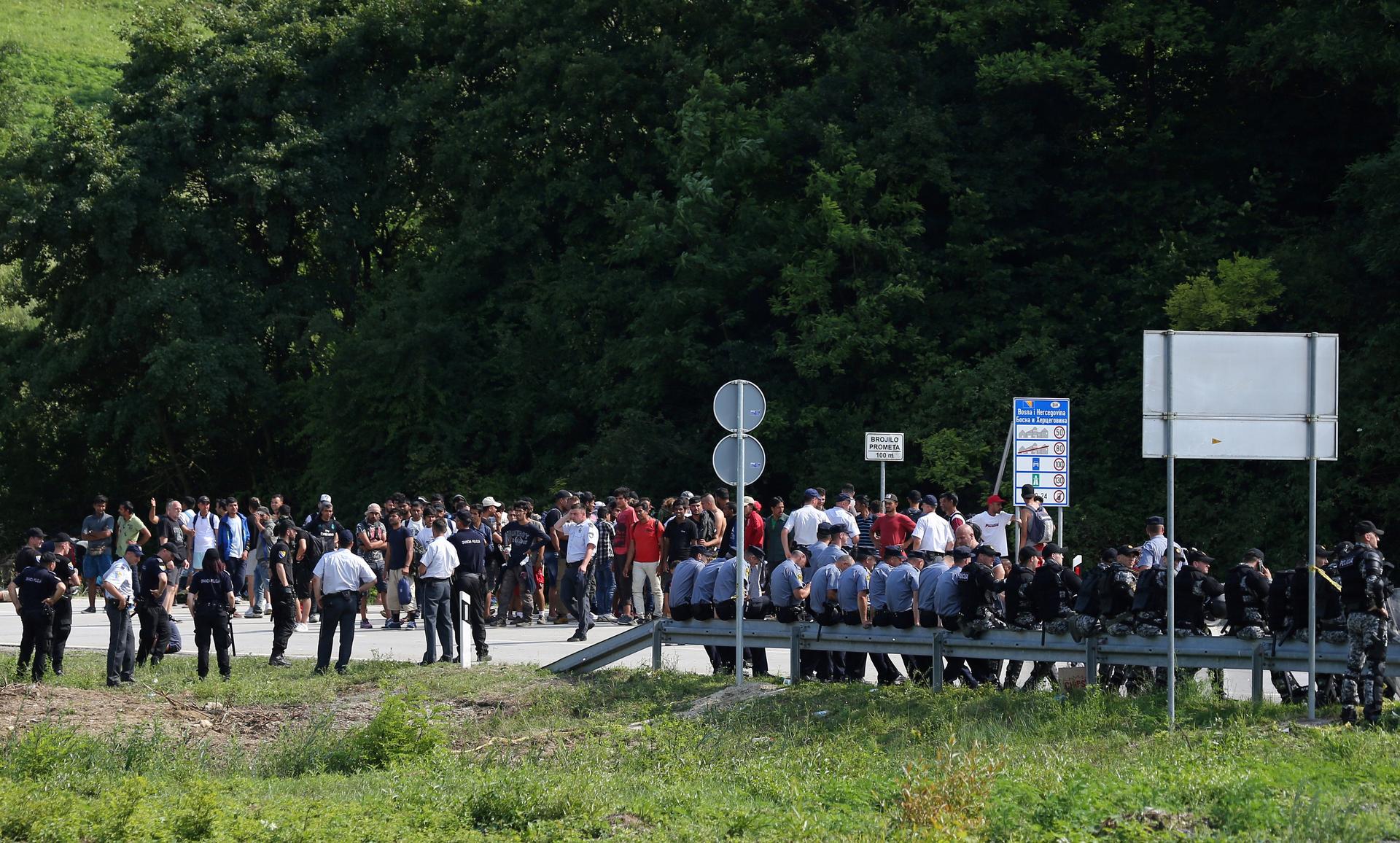 Migrants and Bosnian police are seen next to the border with Croatia in Velika Kladusa, picture taken from Maljevac, Croatia, June 18, 2018.