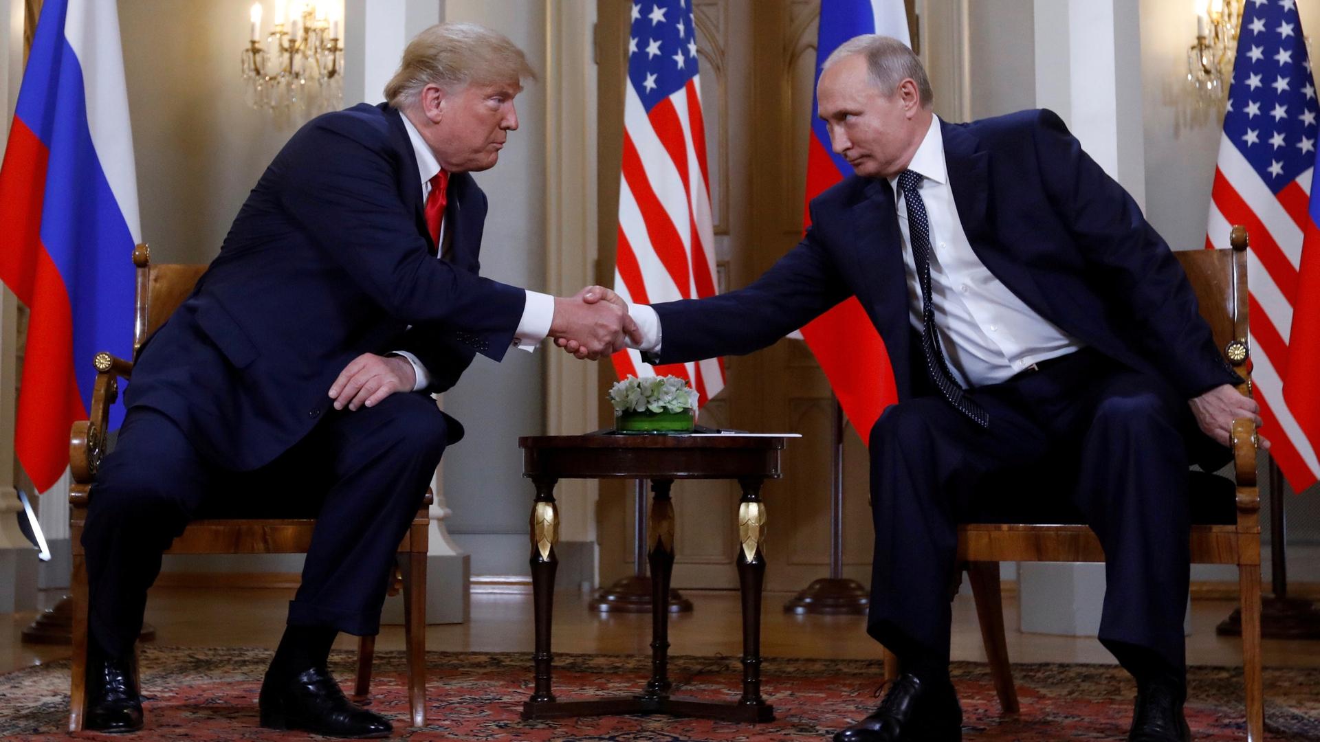 US President Donald Trump and Russia's President Vladimir Putin shake hands as they meet in Helsinki, Finland on July 16, 2018. 