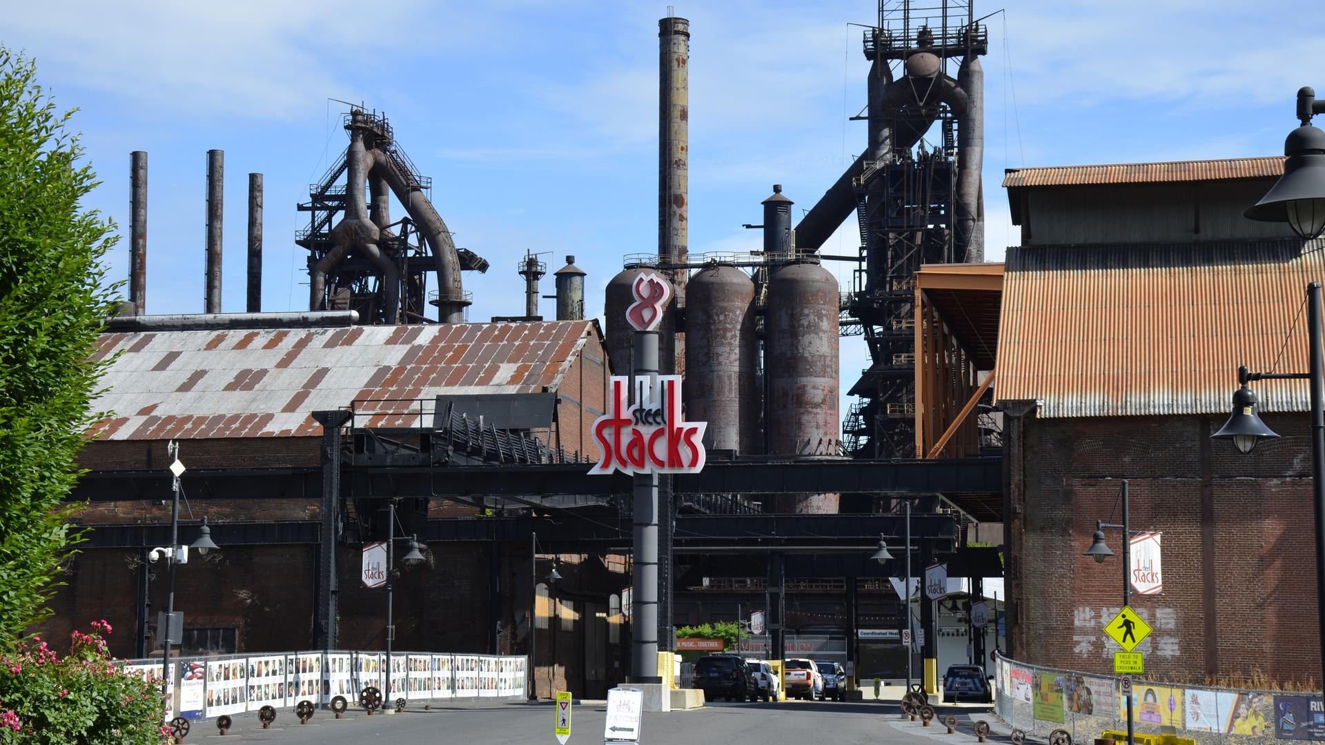 An old building with large mechanical infrastructure now sports a sign reading "SteelStacks" and is a now an entertainment venue. 