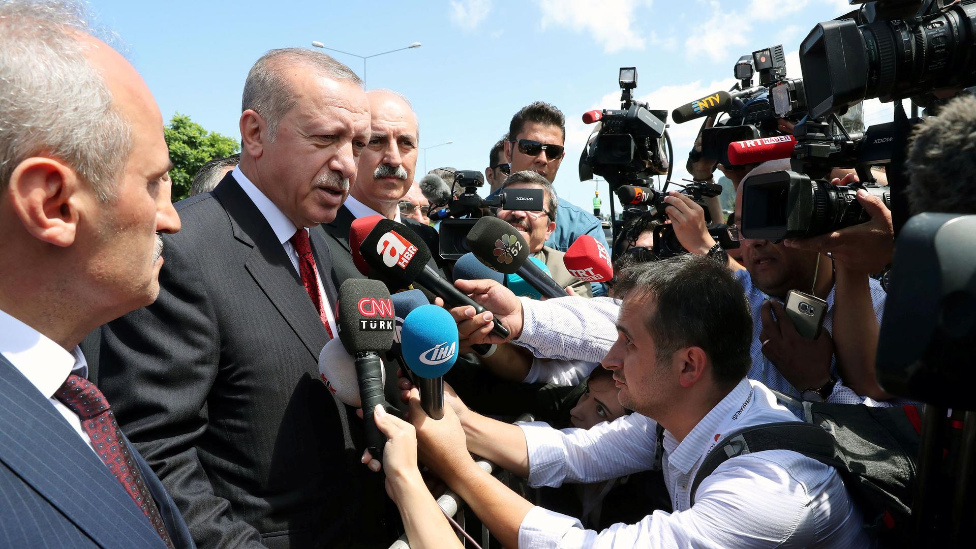 A crowd of reporters surrounds Turkish President Tayyip Erdoğan