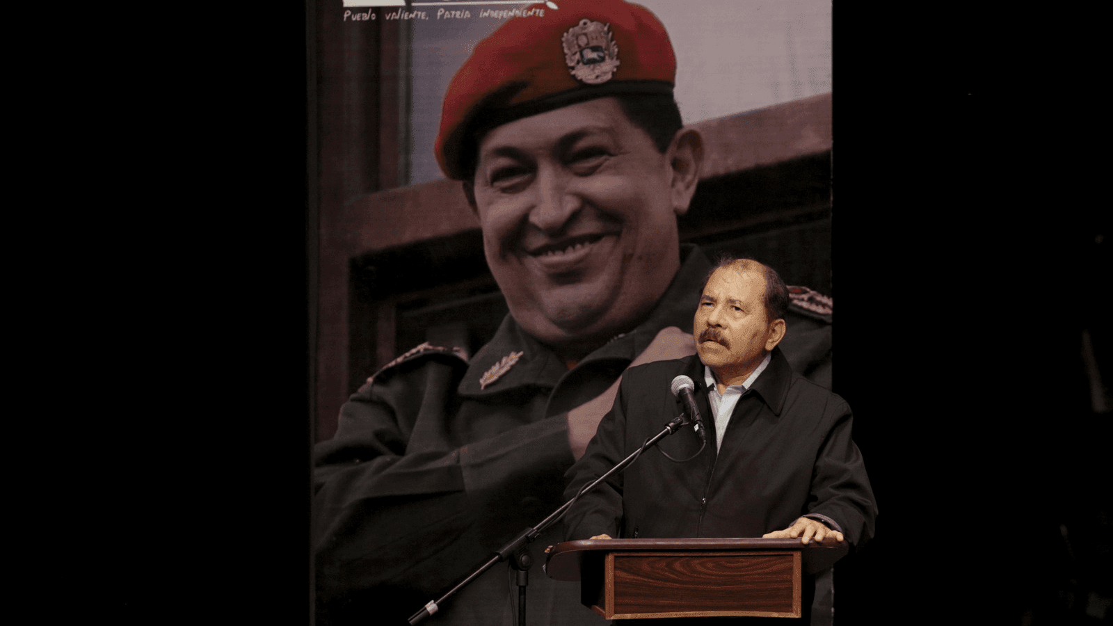Daniel Ortega speaks in front of a huge picture of Hugo Chavez 
