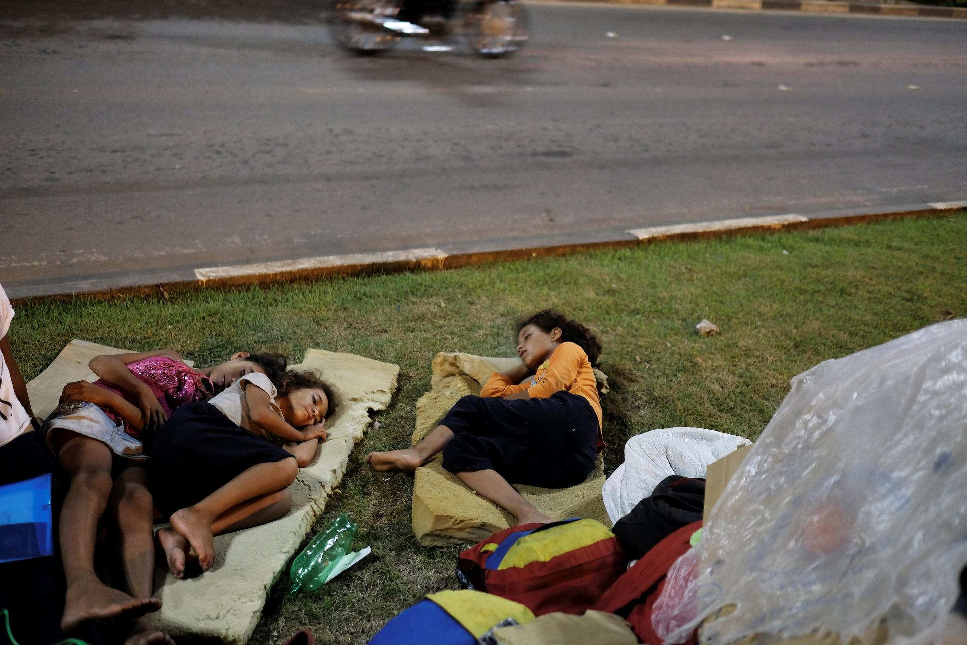 Venezuelan children sleep on the grass