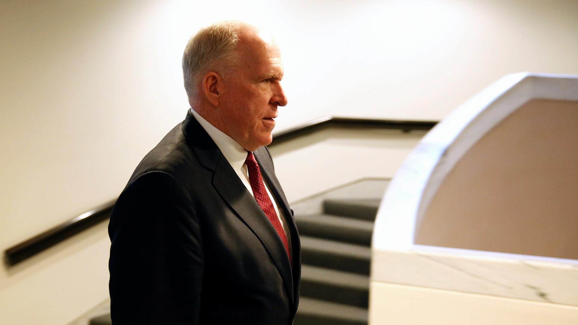 Former CIA Director John Brennan is shown wearing a suit and red tie departing from a Senate Intelligence Committee hearing in Washington, May 2018.