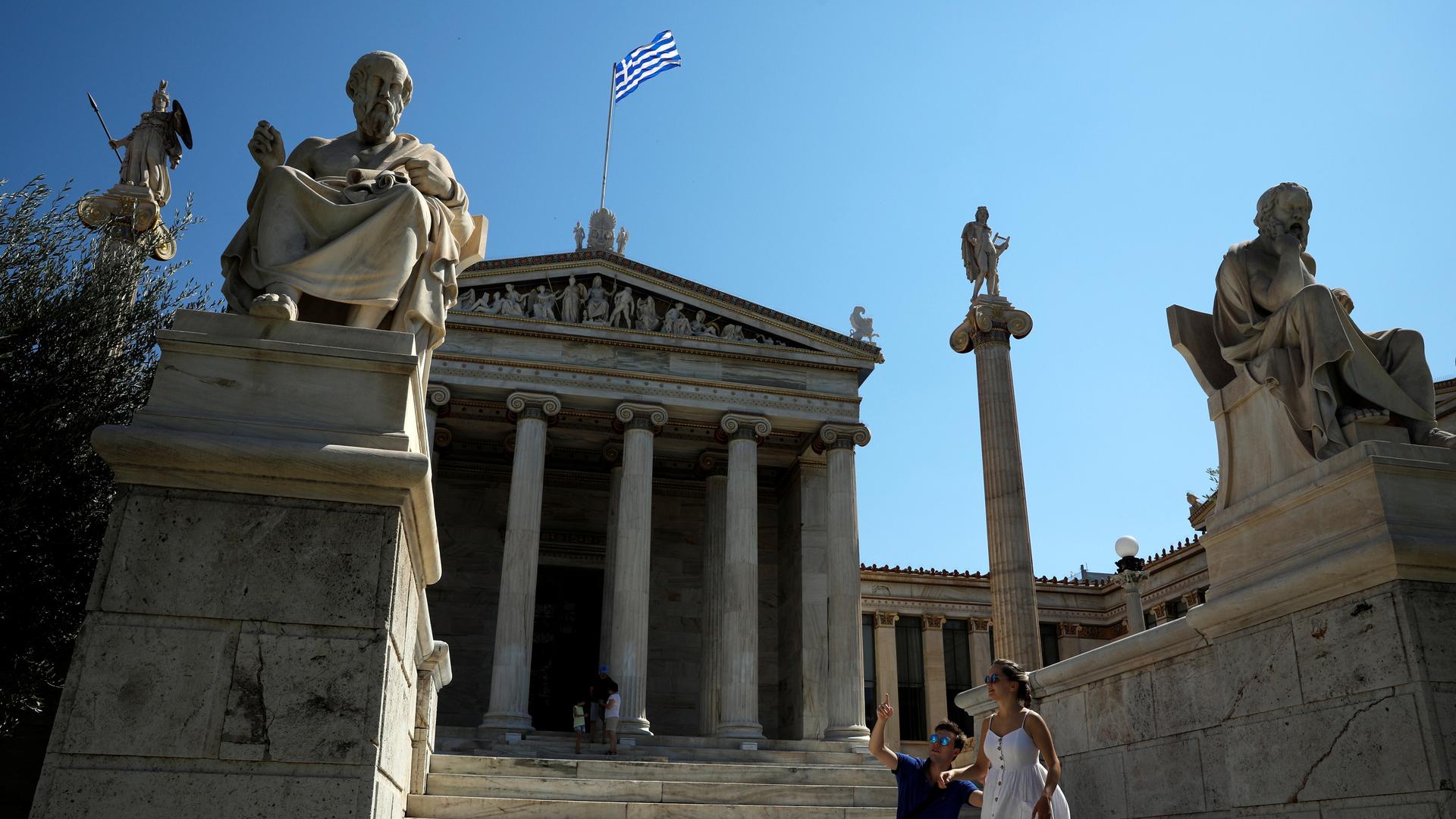 the front steps of front of the Athens Academy in Athens, Greece,