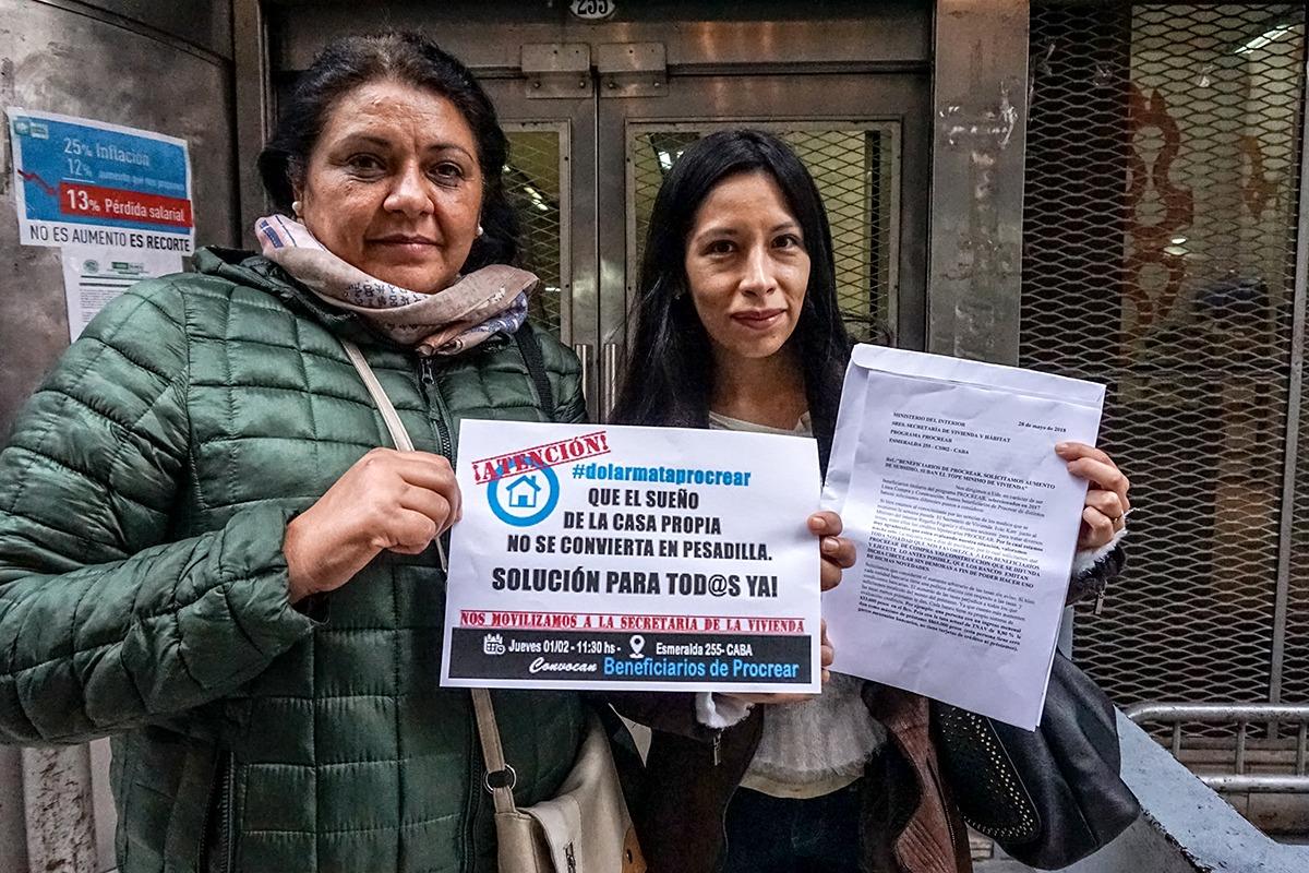 two women in argentina stand in front of a house for sale